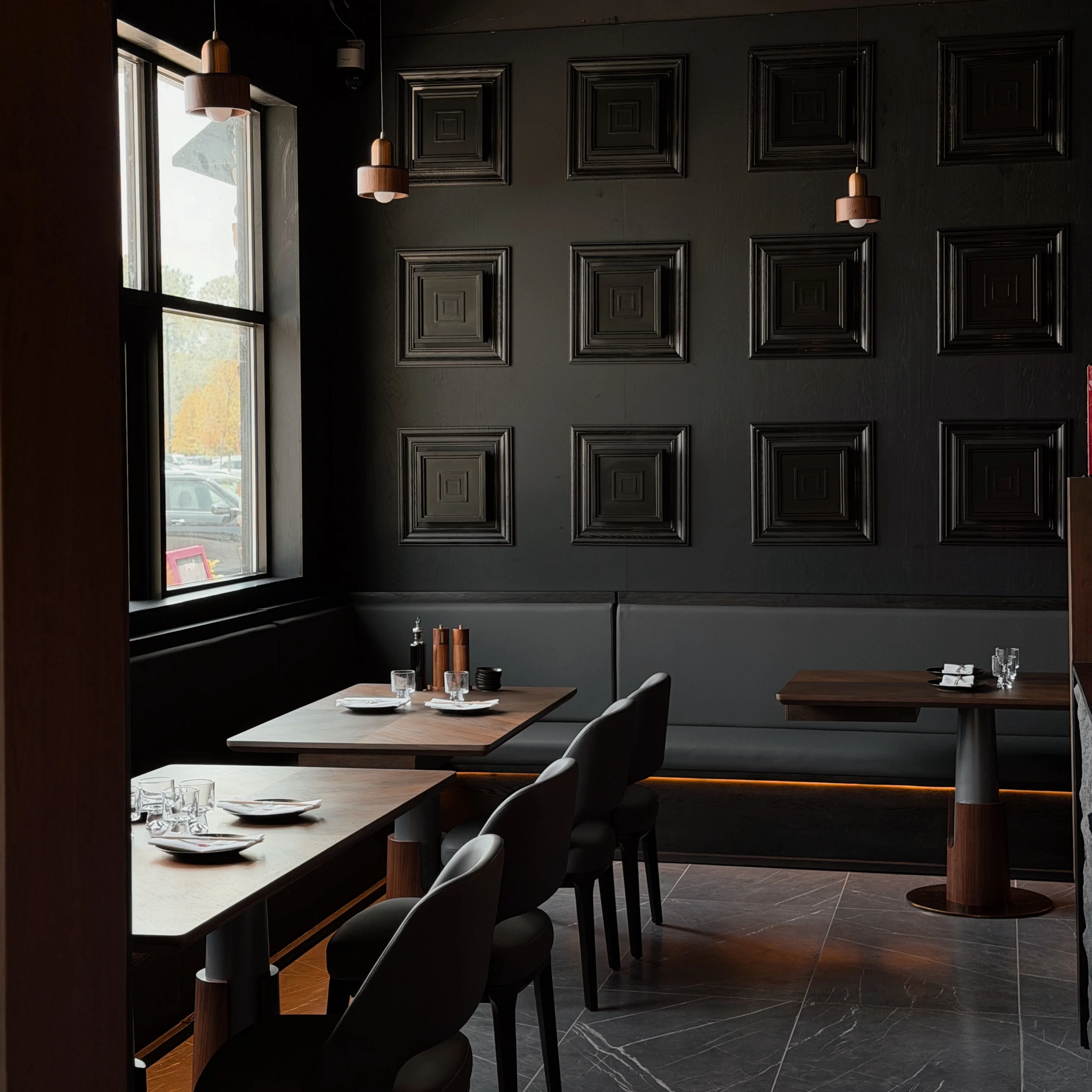 Modern restaurant interior with dark walls and stylish lighting