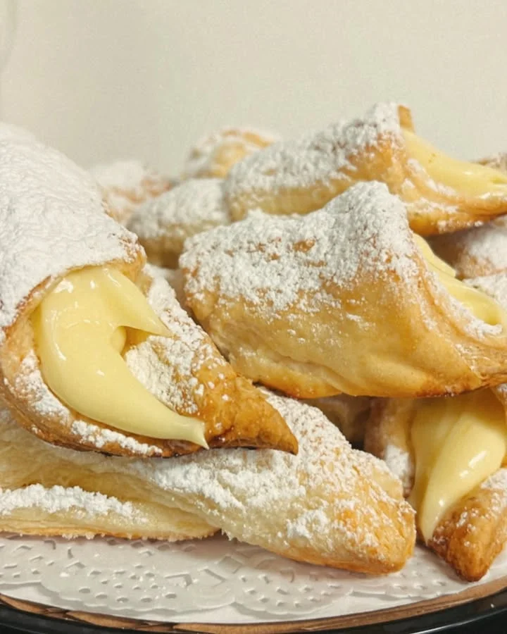 Italian cream-filled pastries dusted with powdered sugar