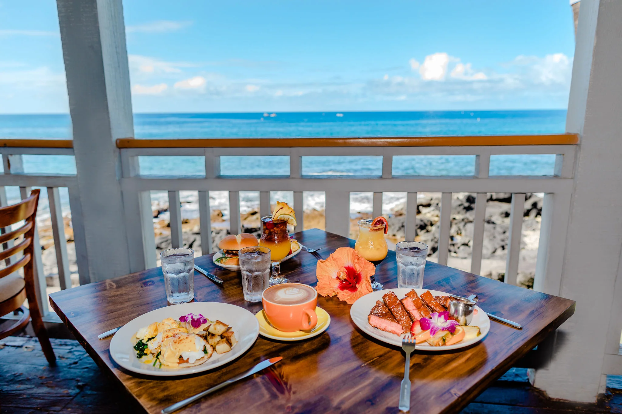 Hawaiian breakfast with eggs benedict and tropical drinks by the ocean