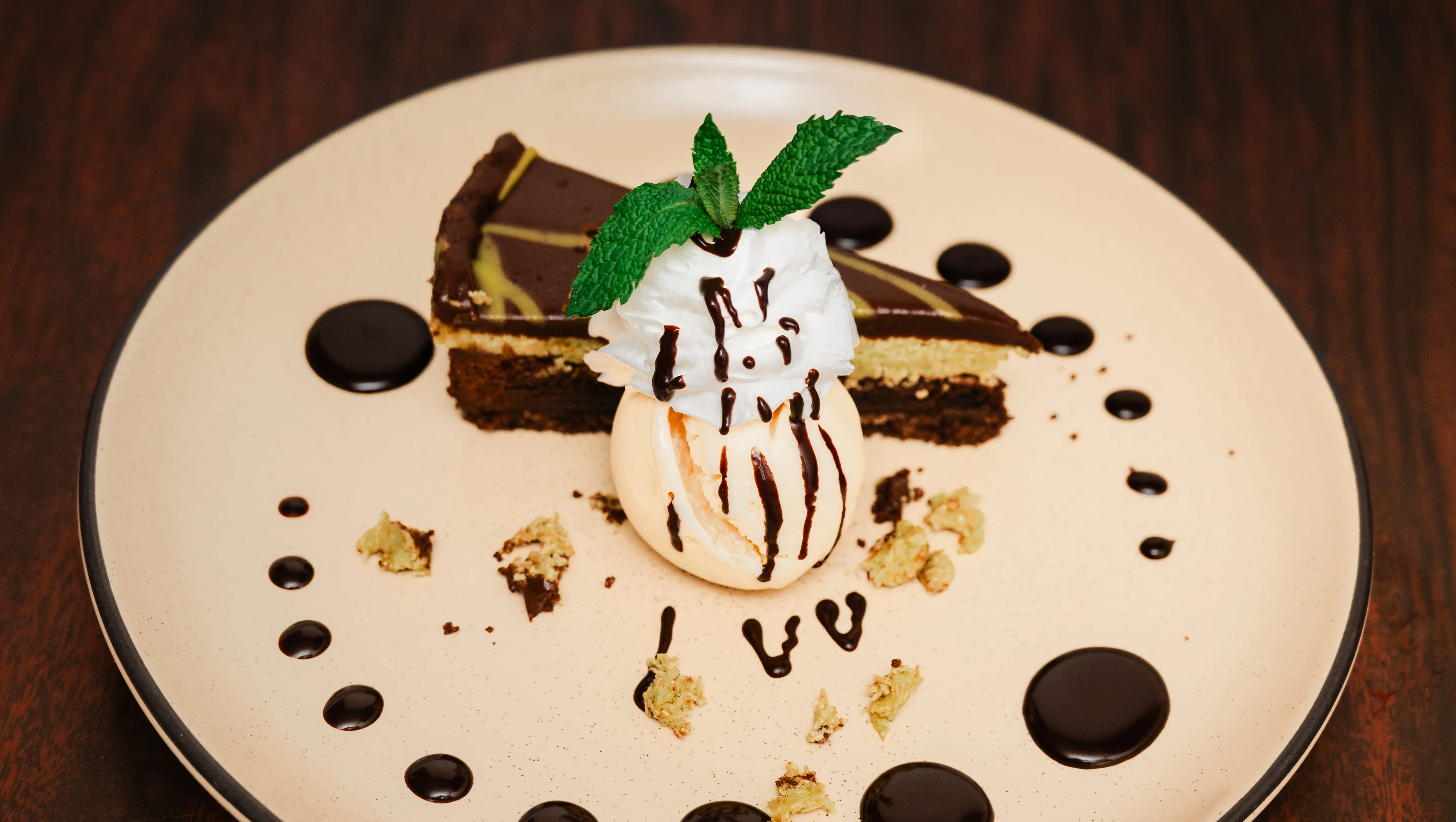 Decadent chocolate cake slice with ice cream and chocolate sauce