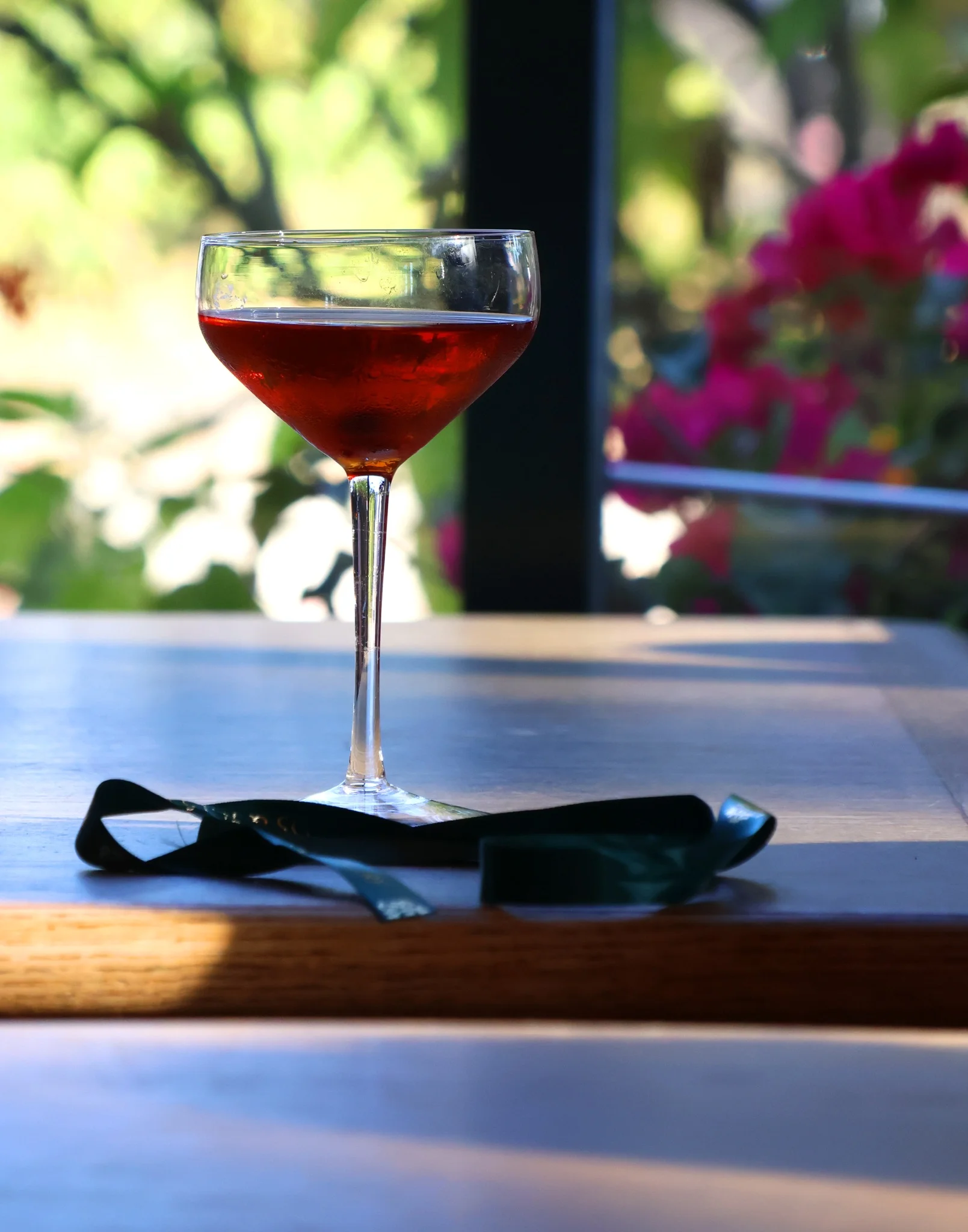 Elegant cocktail in a coupe glass on a wooden table