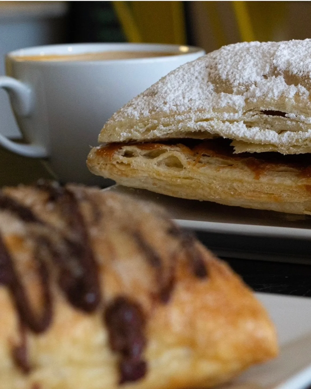 Flaky French pastry with coffee in a cozy café setting