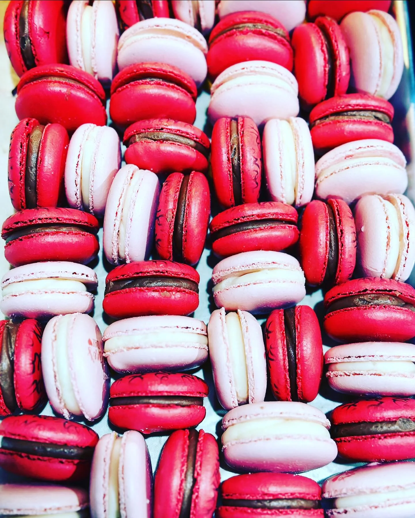 Colorful assortment of French macarons in pink and red hues