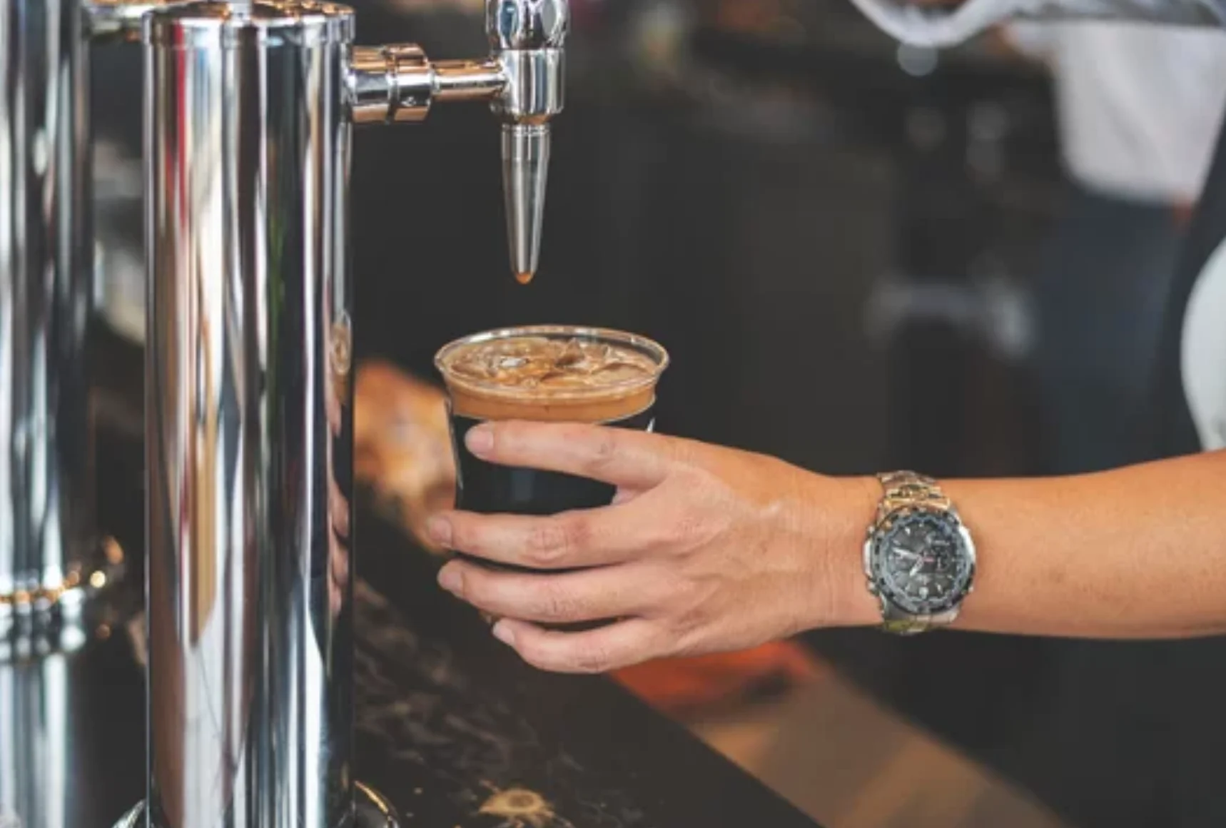 A glass of nitro cold brew coffee with a creamy head.
