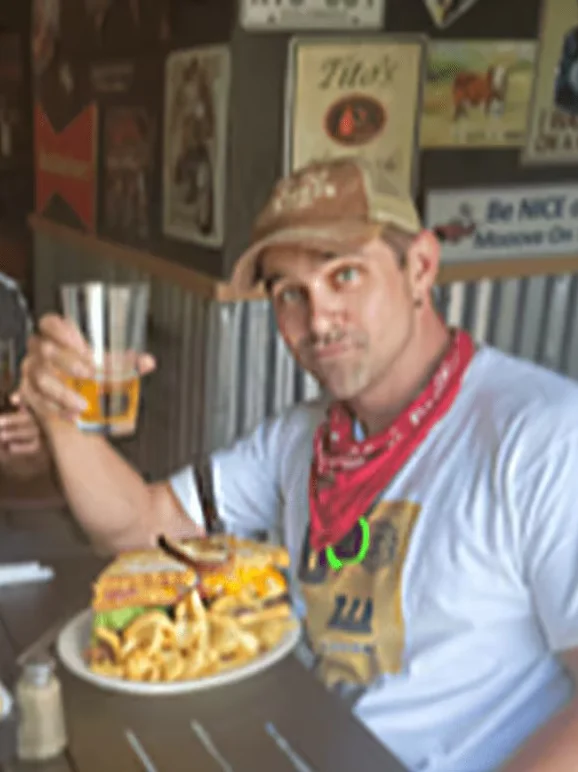 Two friends enjoying burgers and drinks in a lively restaurant setting