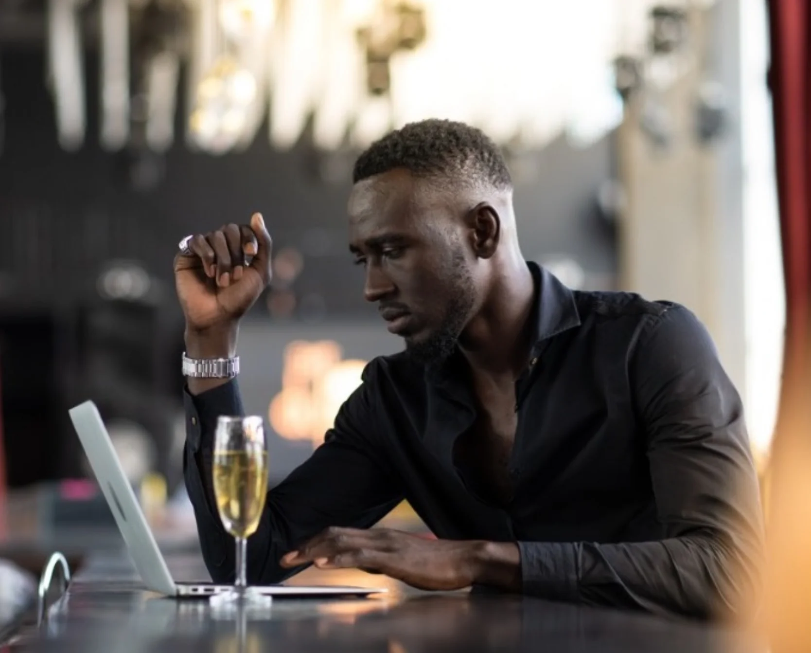 Man at Tolex Grill enjoying drink and working on computer