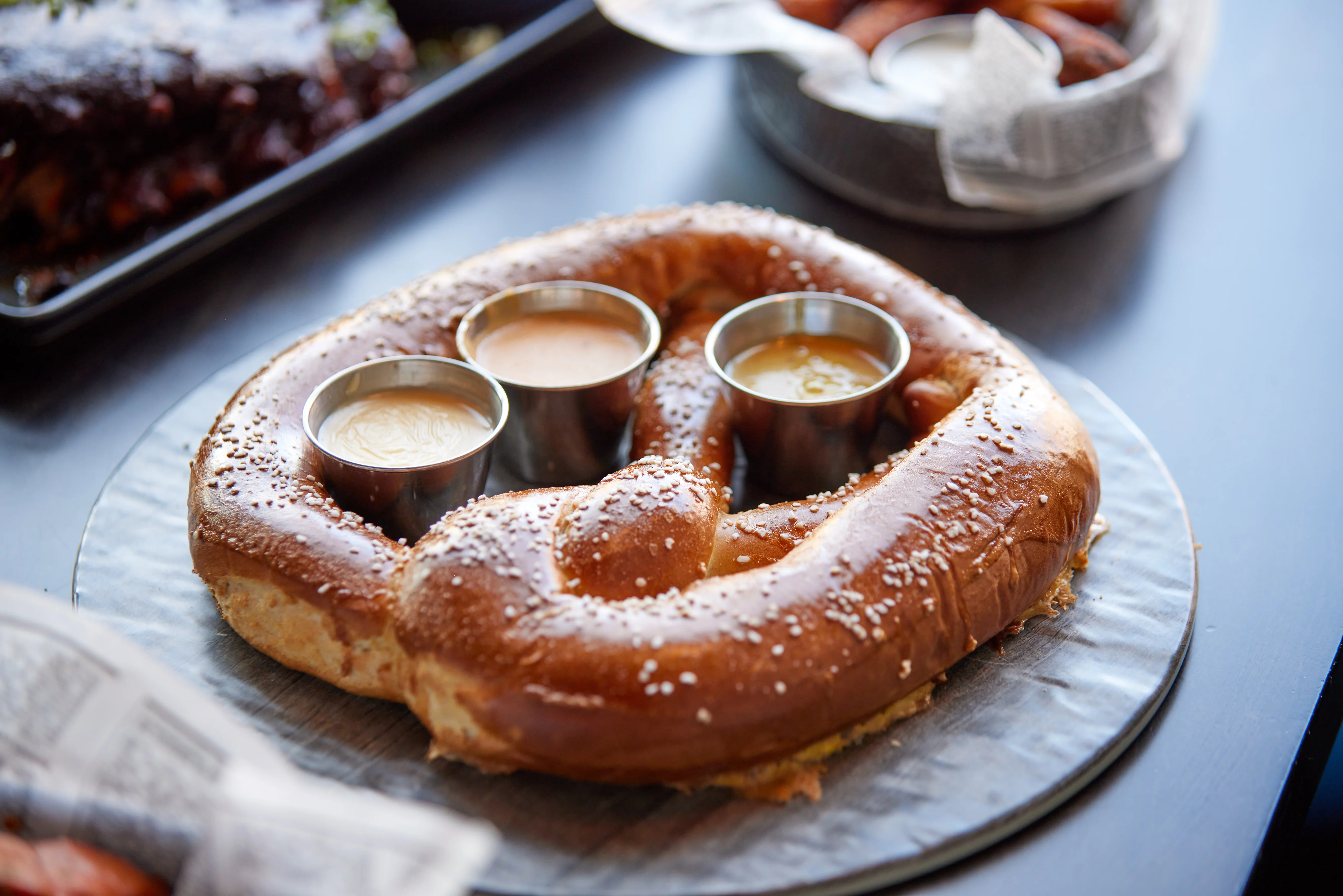 Giant soft pretzel served with dipping sauces