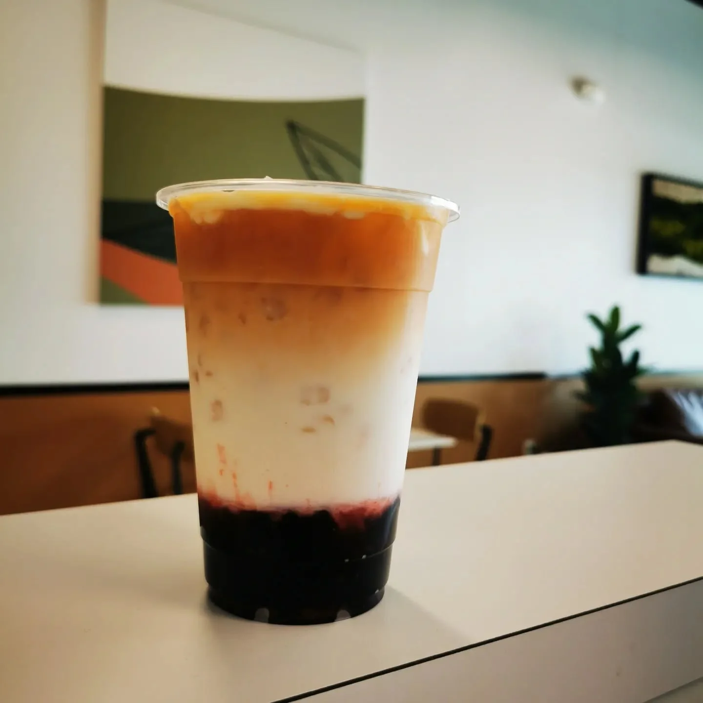 Layered iced coffee with milk and fruit syrup