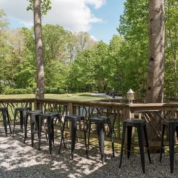 Outdoor bar seating surrounded by lush greenery