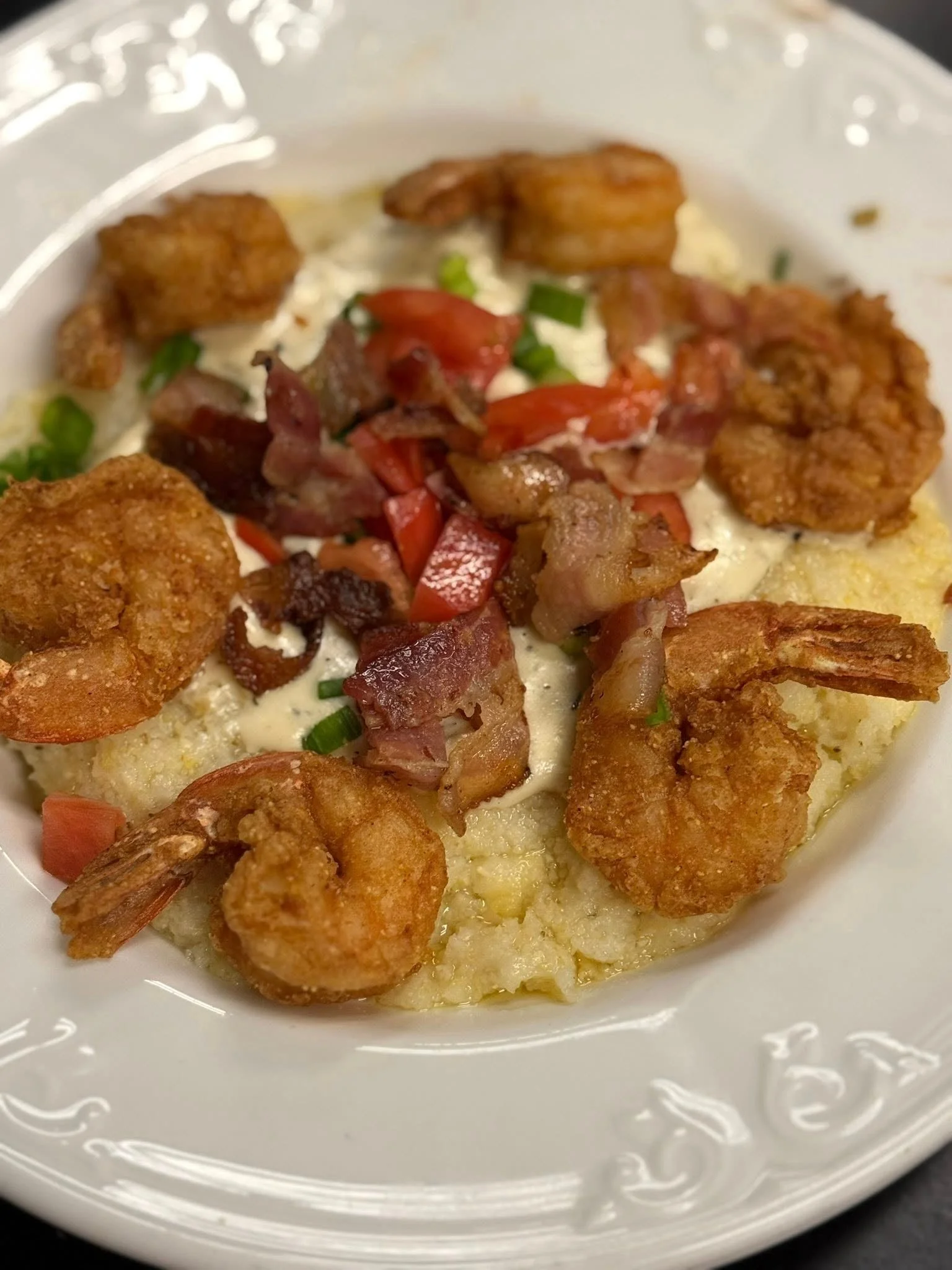 Southern shrimp and grits topped with bacon and tomatoes