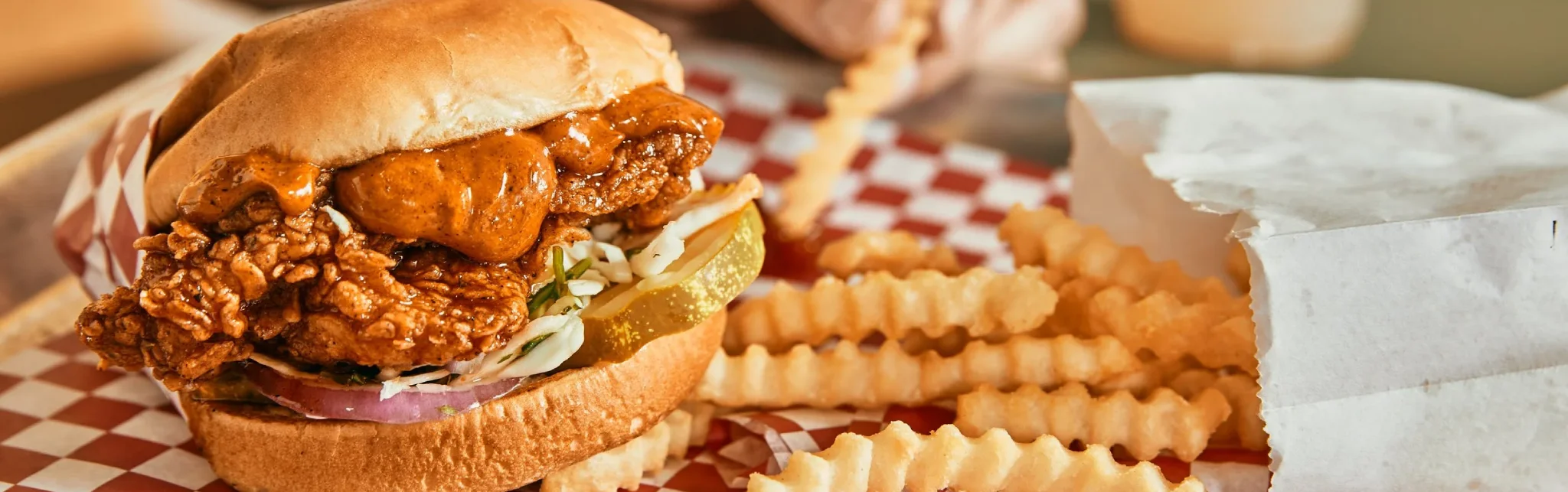 Crispy fried chicken sandwich with pickles and crinkle-cut fries