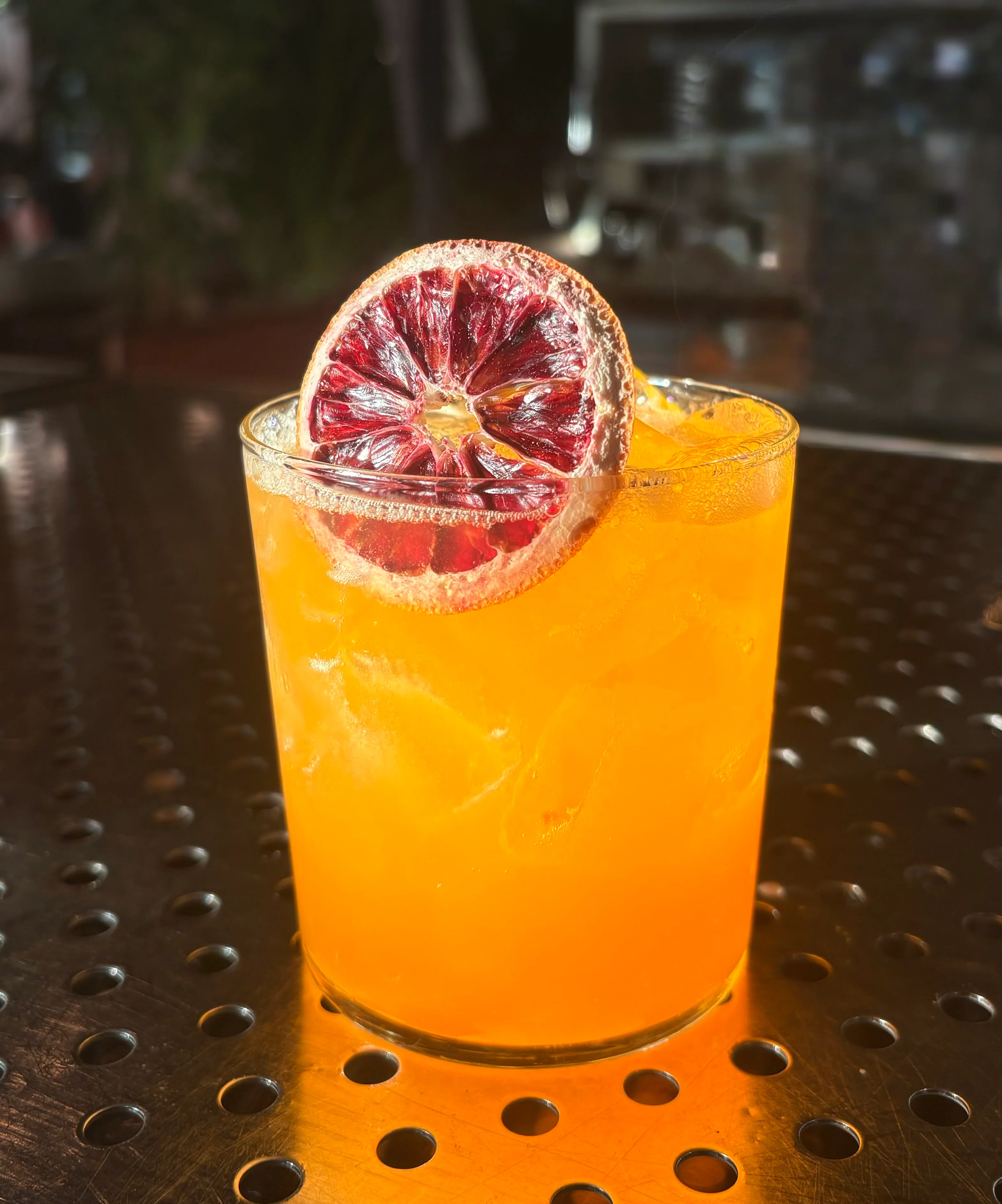 Vibrant cocktail garnished with dried blood orange slice