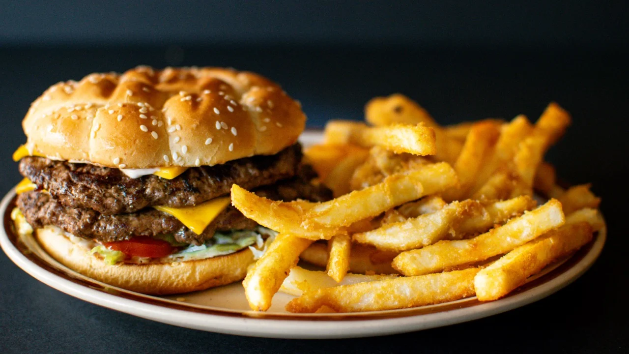Juicy cheeseburger with fries on a plate
