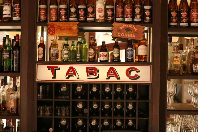 Well-stocked bar with various bottles and TABAC signage