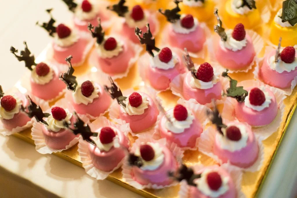 Colorful raspberry mousse desserts with cream topping