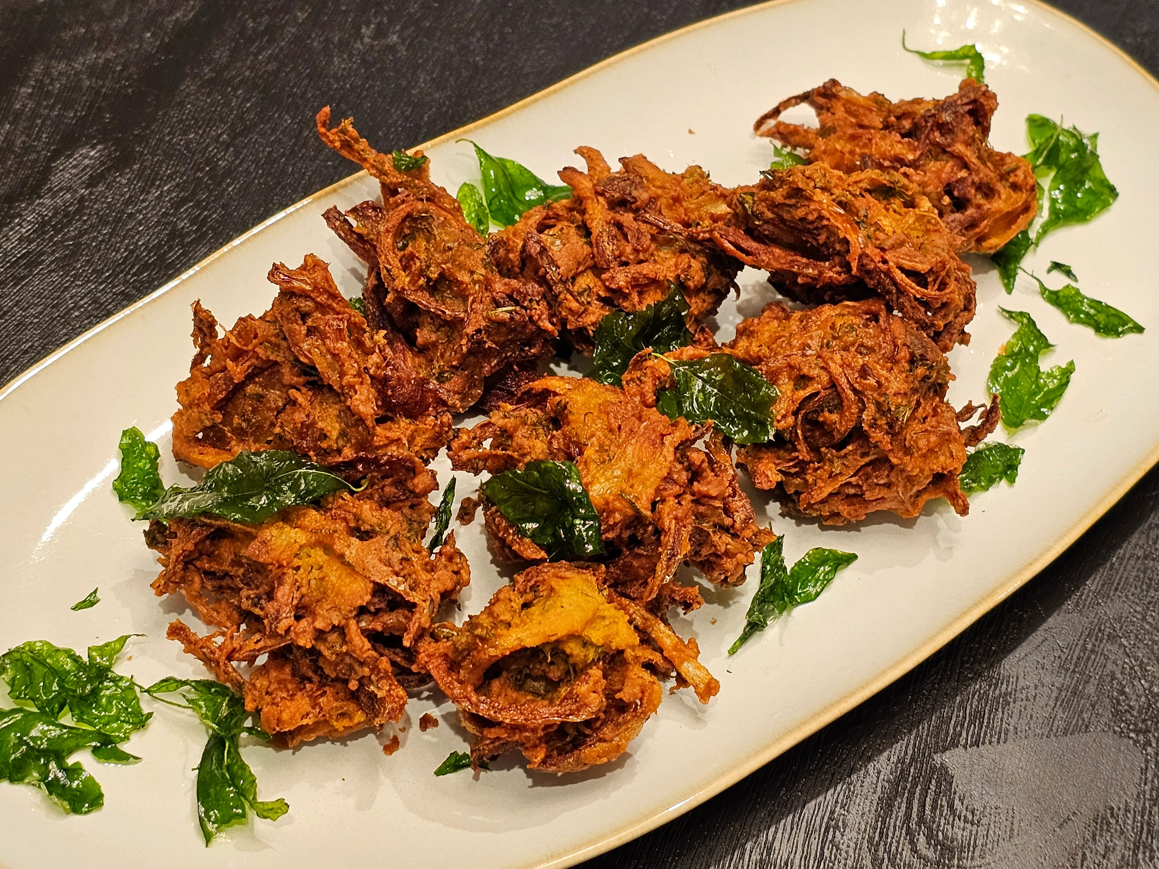 Crispy Indian onion bhaji served with fresh herbs
