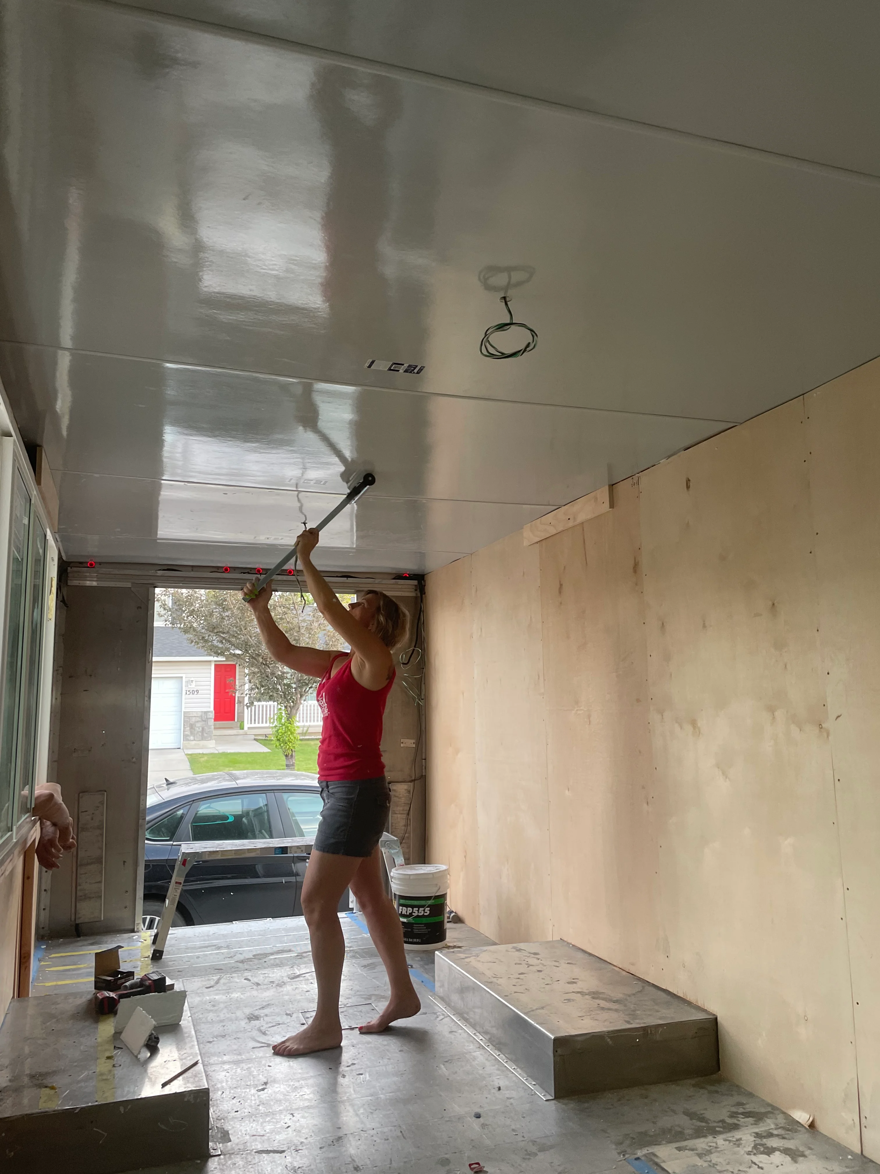 Person painting a ceiling in a home renovation project