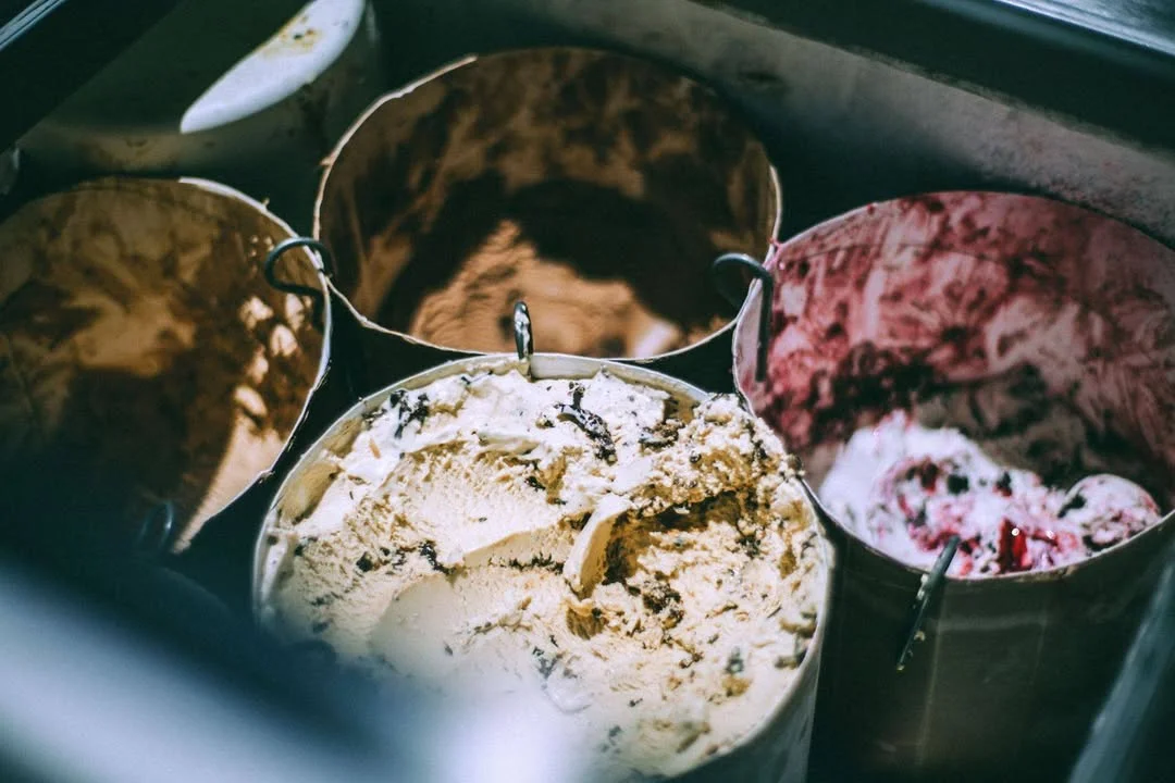 Assorted ice cream flavors in metal tubs