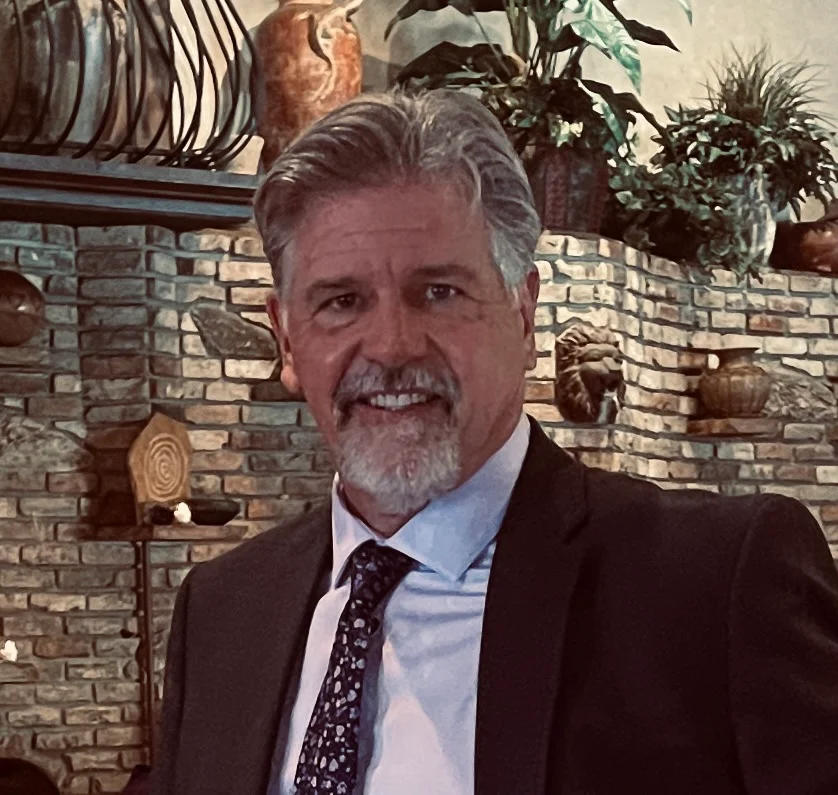 Professional man in a suit smiling in a cozy restaurant setting