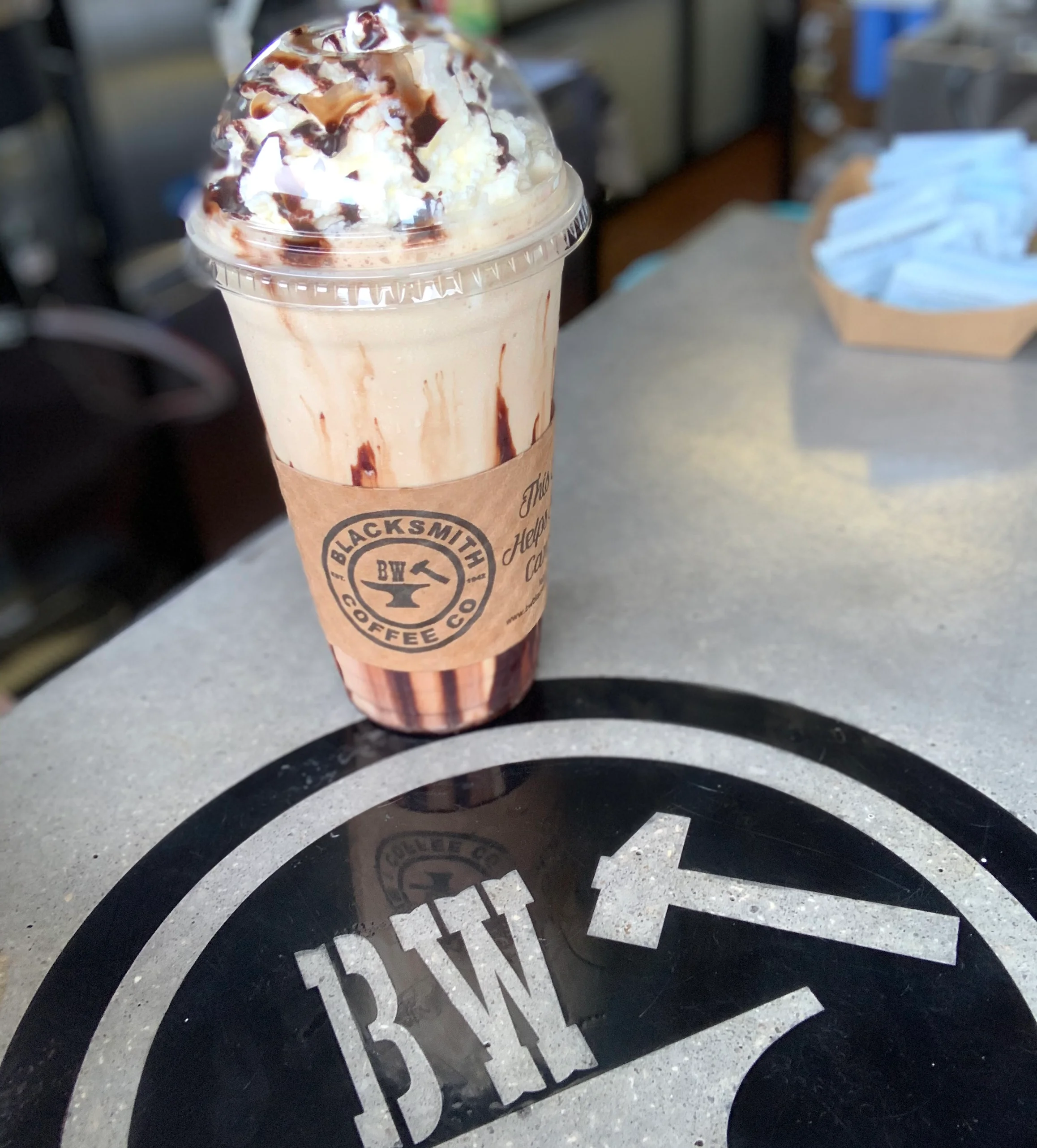 Frosted coffee drink topped with whipped cream and chocolate drizzle