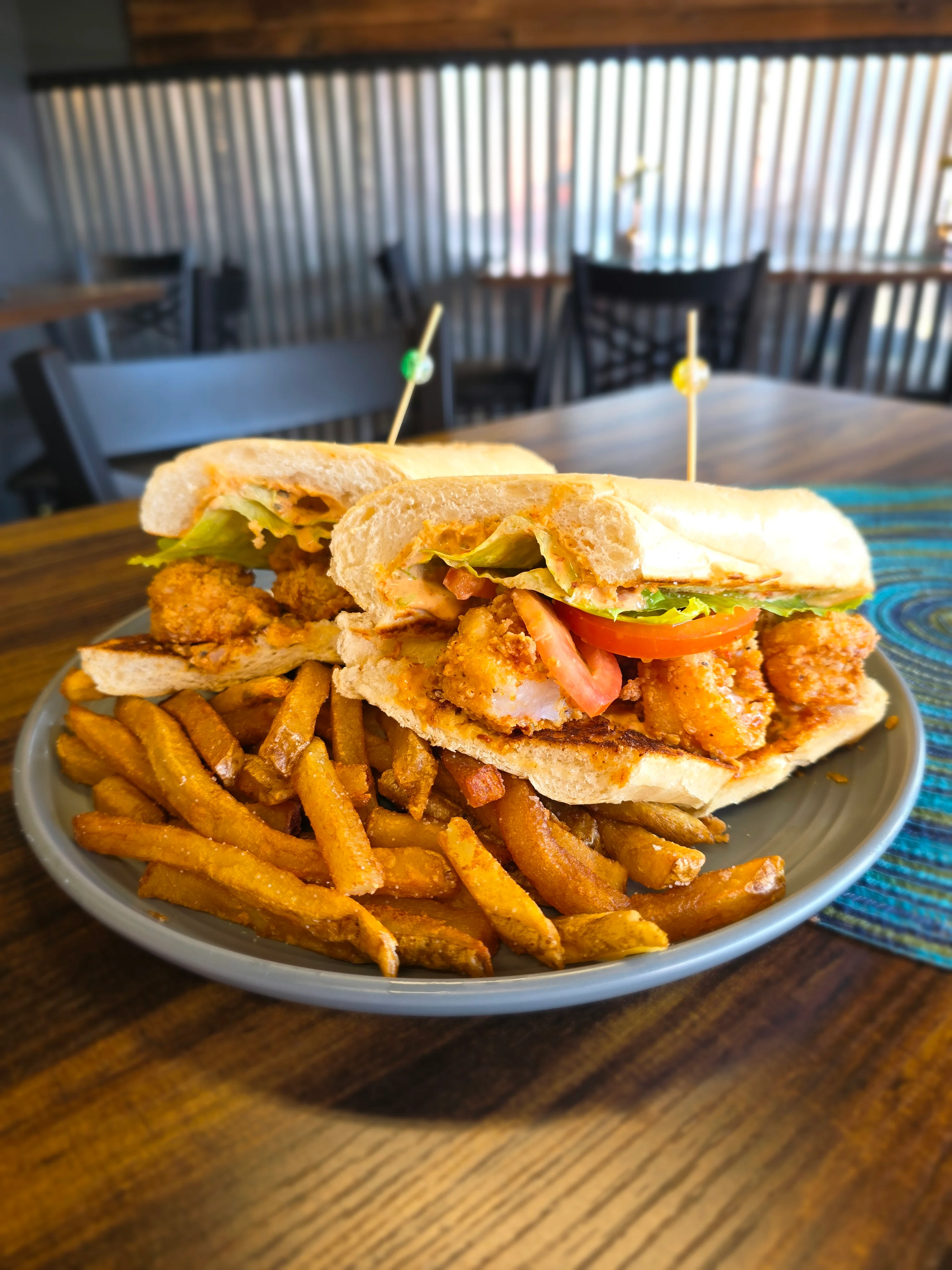 Crispy fried shrimp po' boy sandwich with seasoned fries