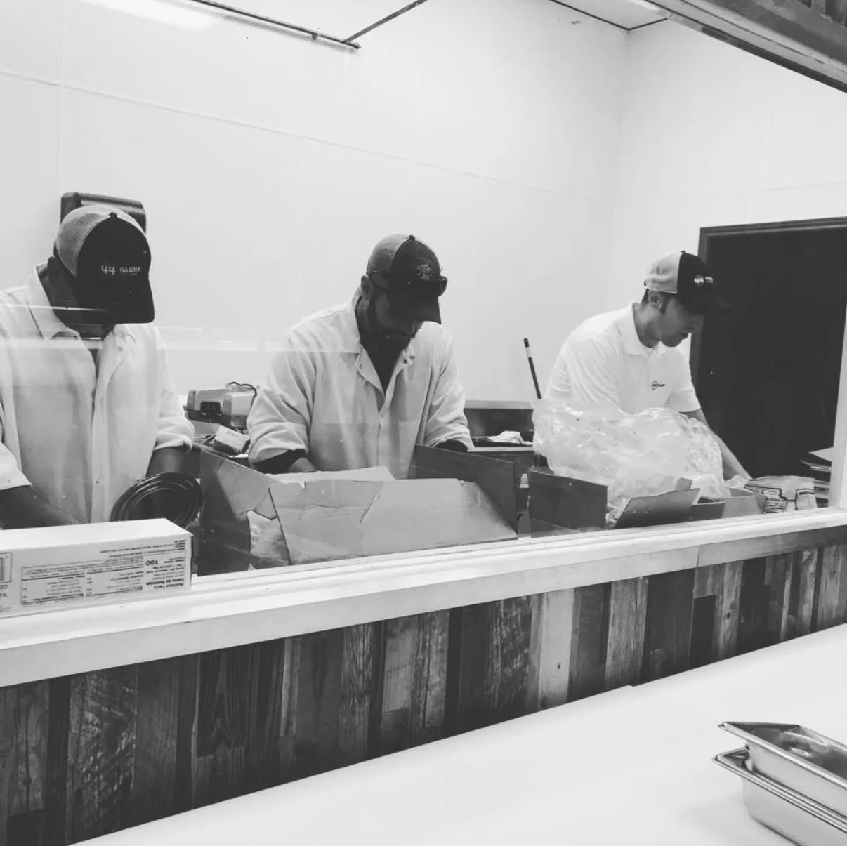 Three workers in a restaurant kitchen preparing food.