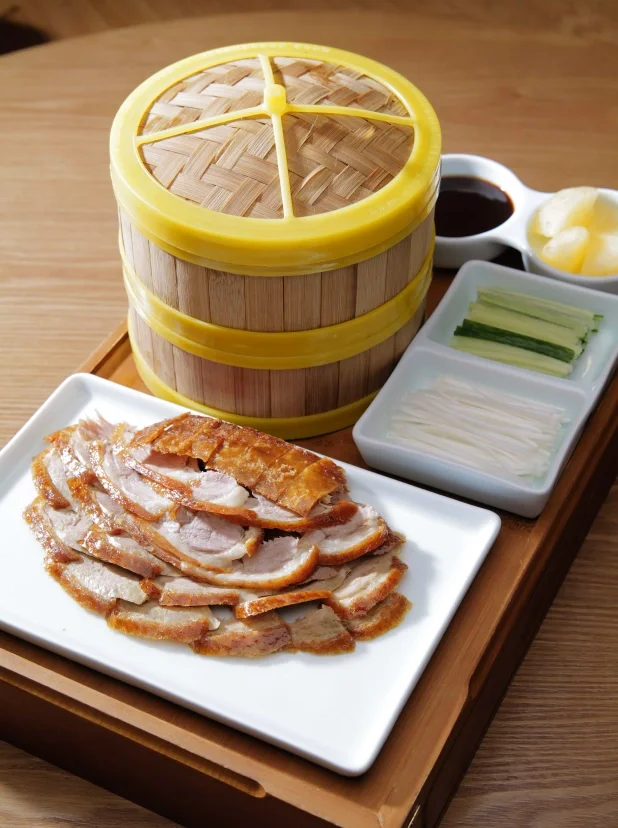 Crispy Peking duck served with pancakes and condiments