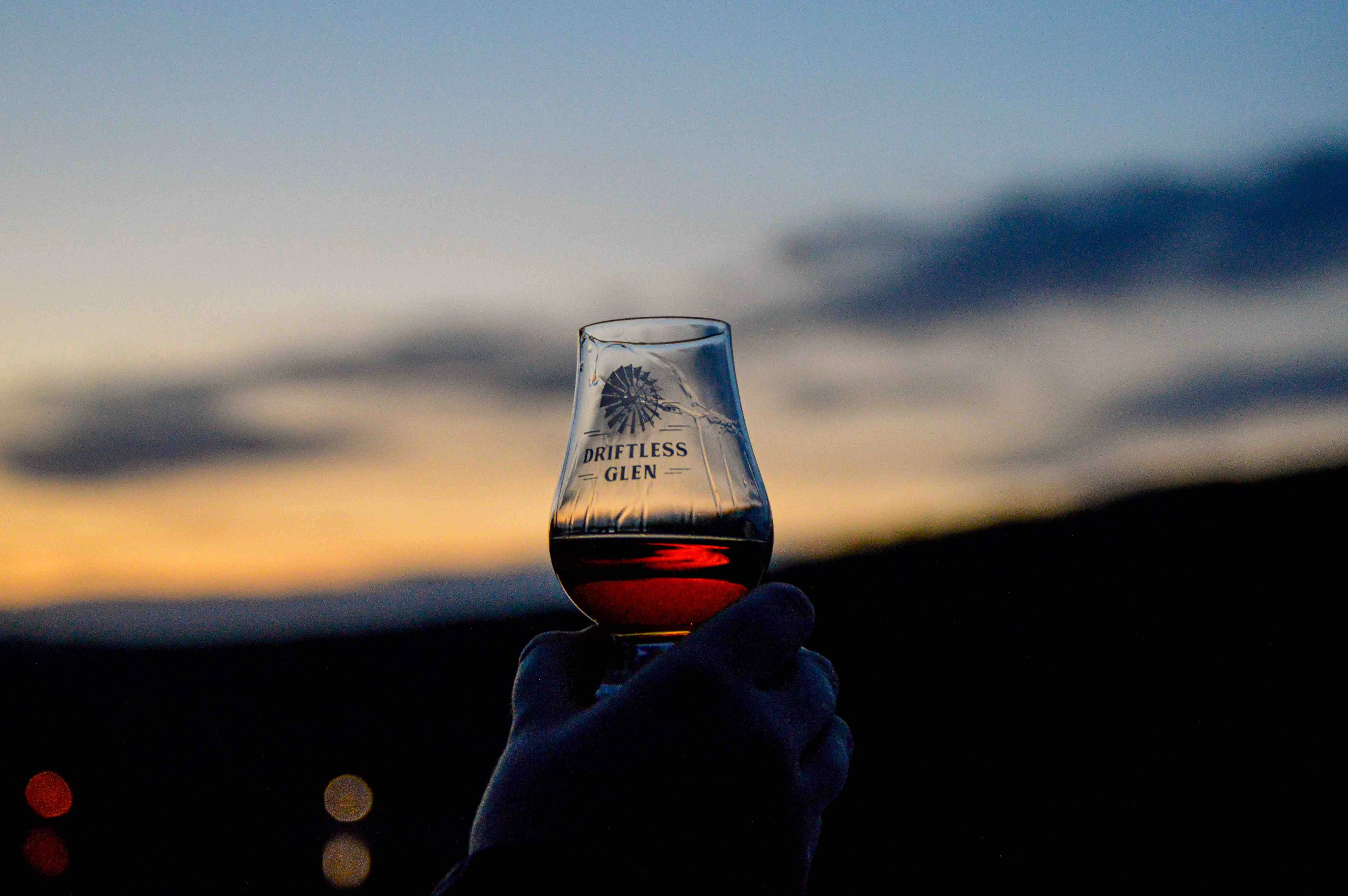 Someone holding a Glencairn in front of a sunset