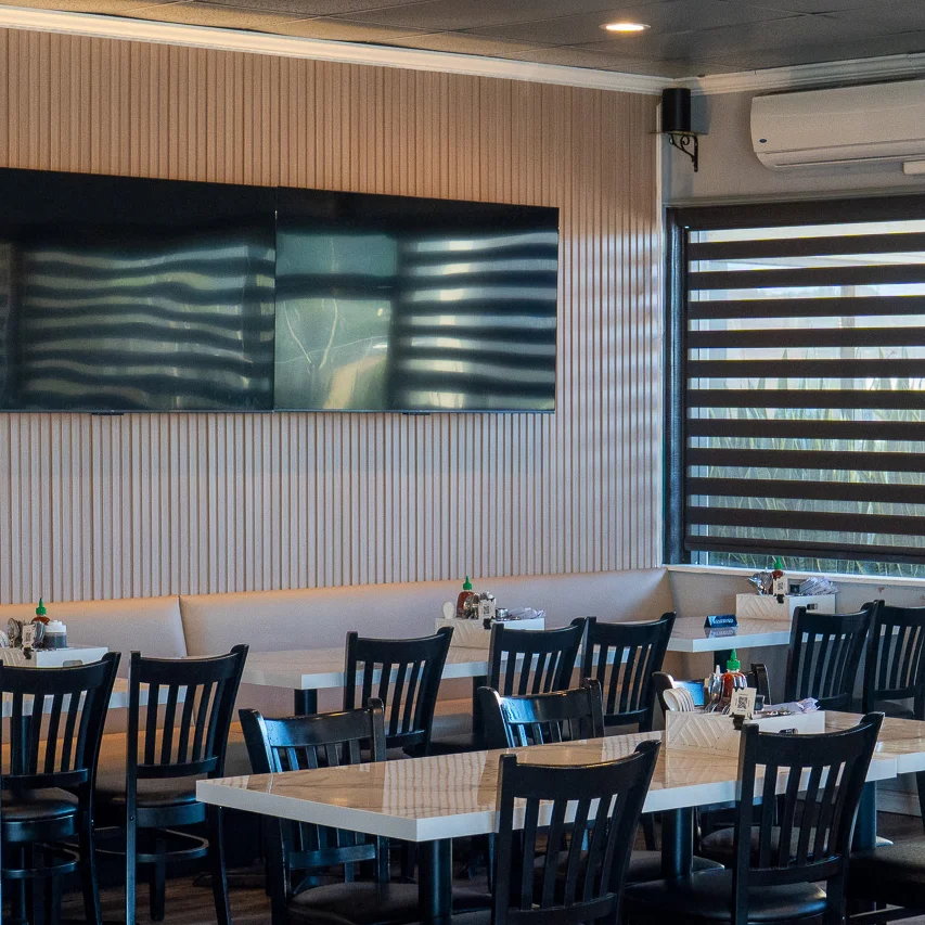Modern restaurant interior with black chairs and large windows