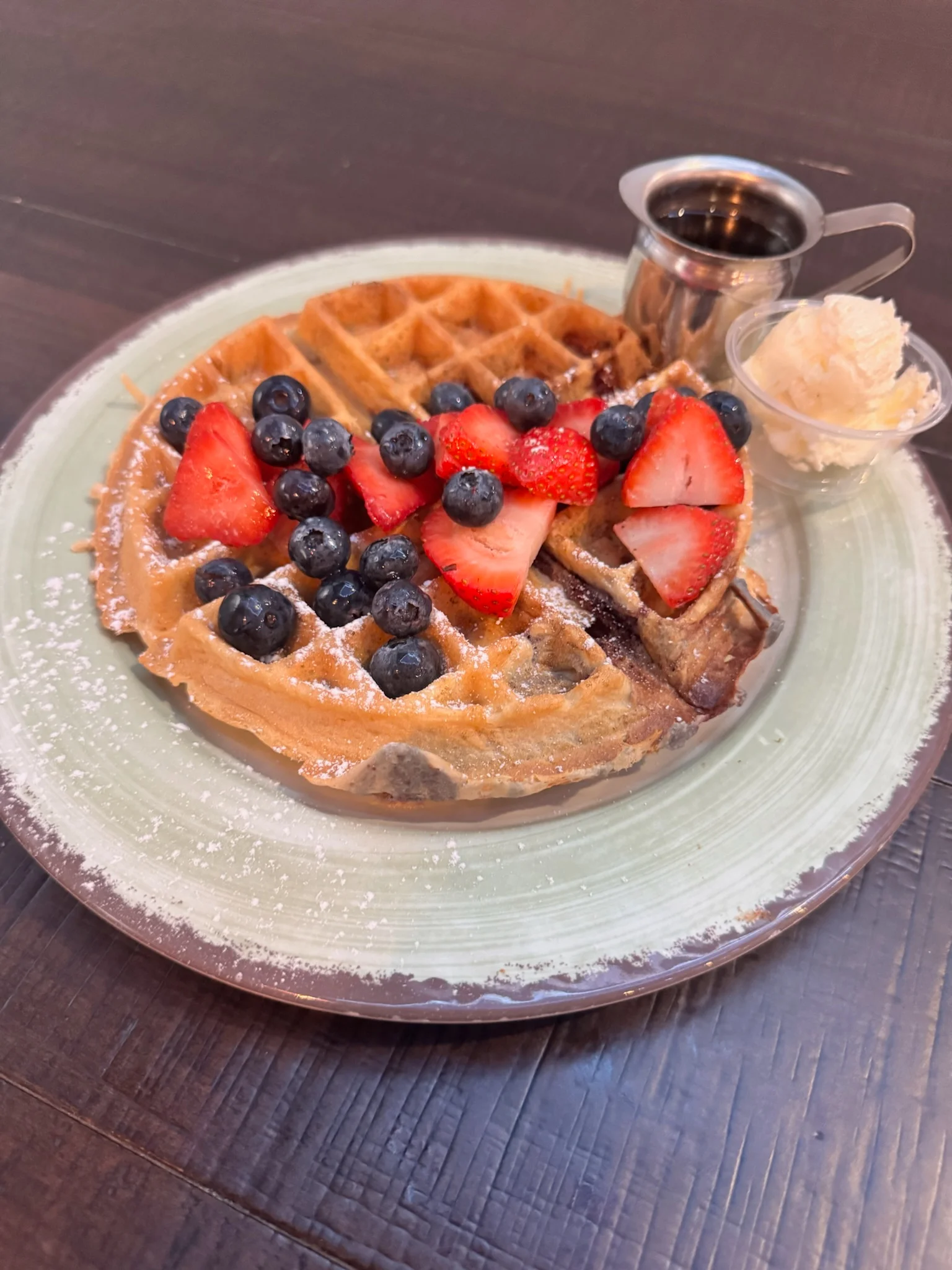 Belgian waffle topped with fresh berries and whipped cream