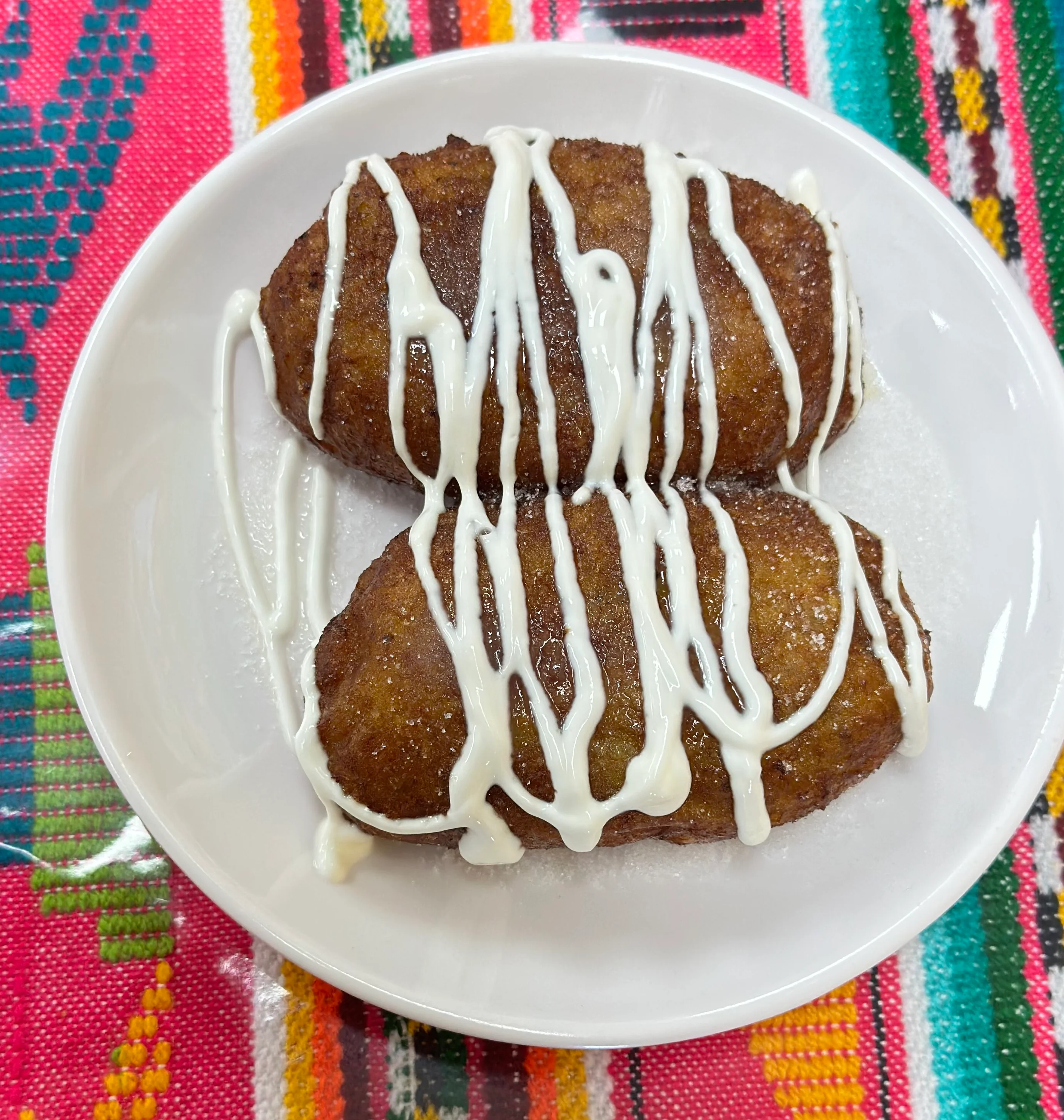 Delicious Mexican buñuelos drizzled with cream