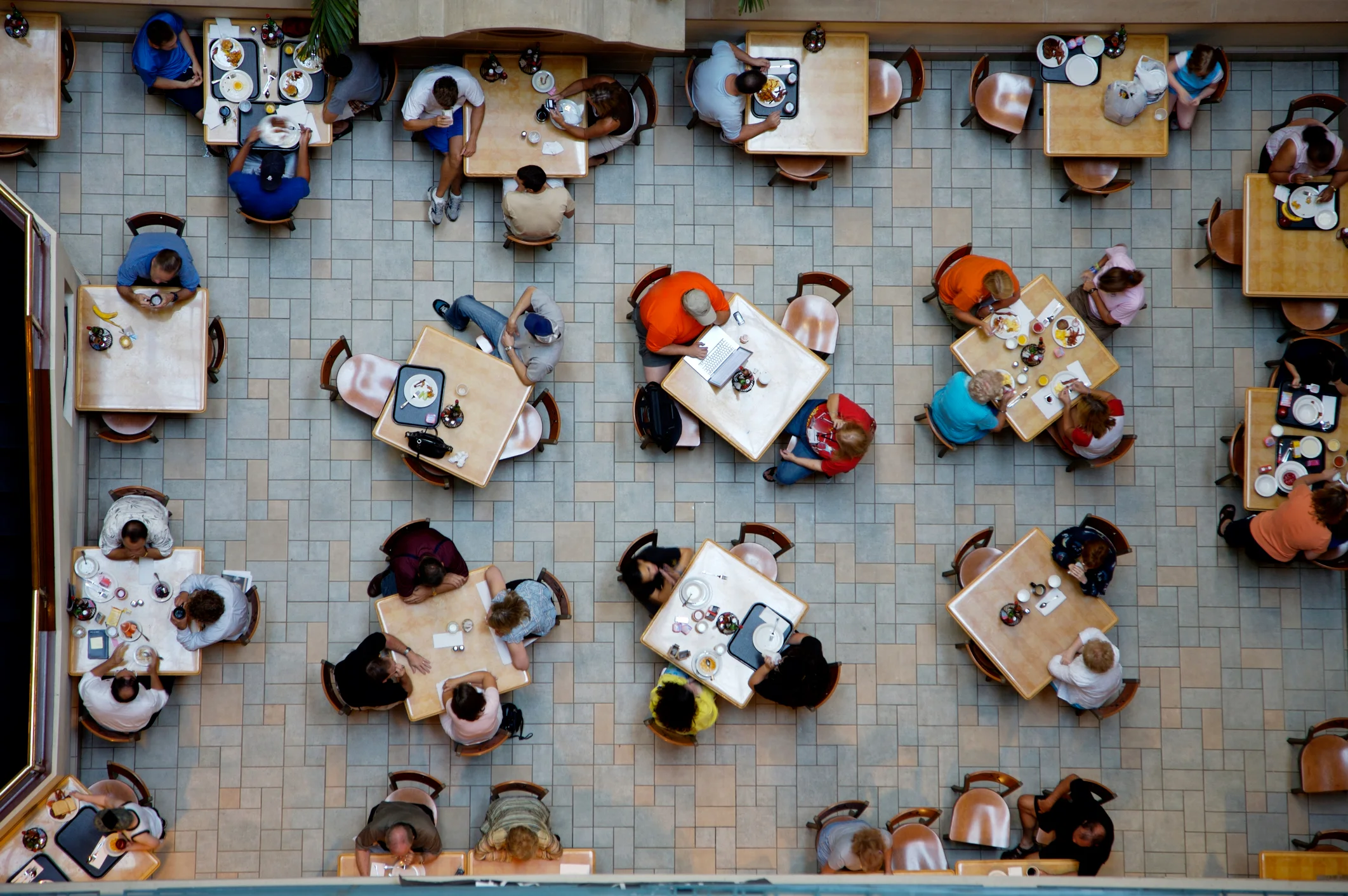 Aerial view of a bustling restaurant dining area with tables and patrons