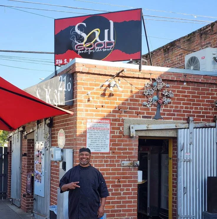 Exterior view of Soul Good restaurant with chef and signage