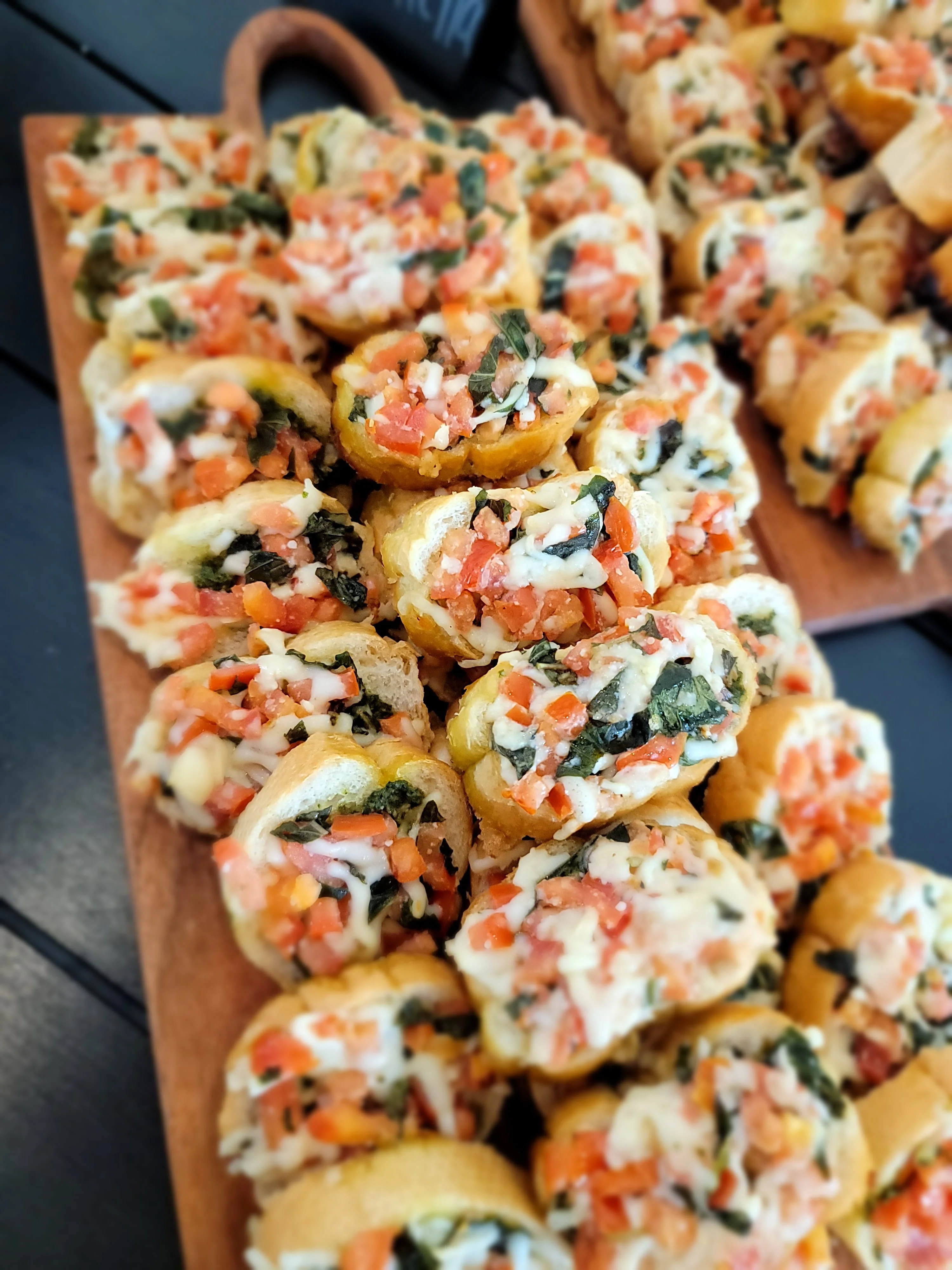 Savory Italian spinach and tomato rolls on a wooden platter