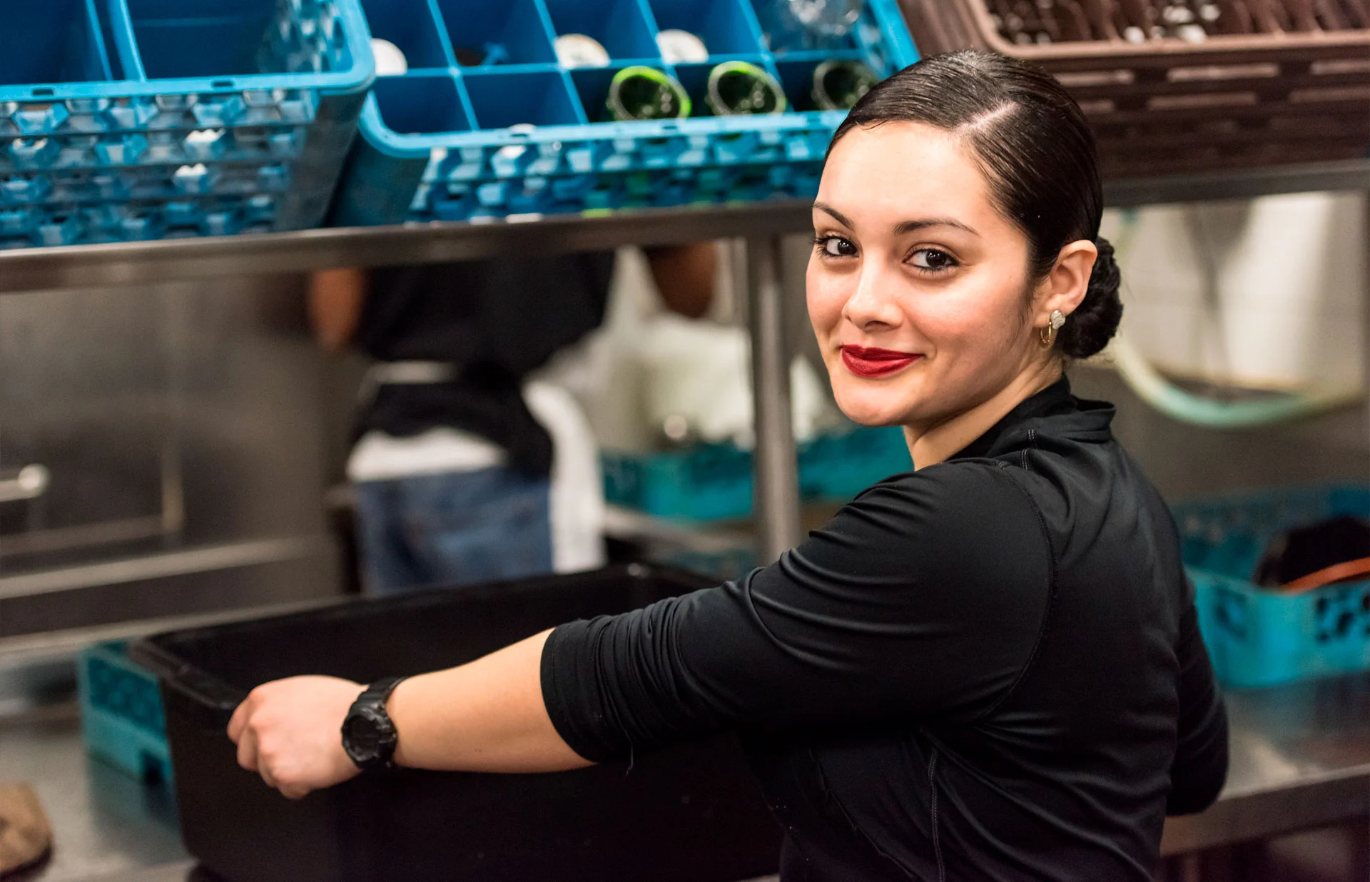 Restaurant staff member in kitchen smiling while working