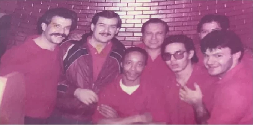 Group of restaurant staff posing together in red uniforms