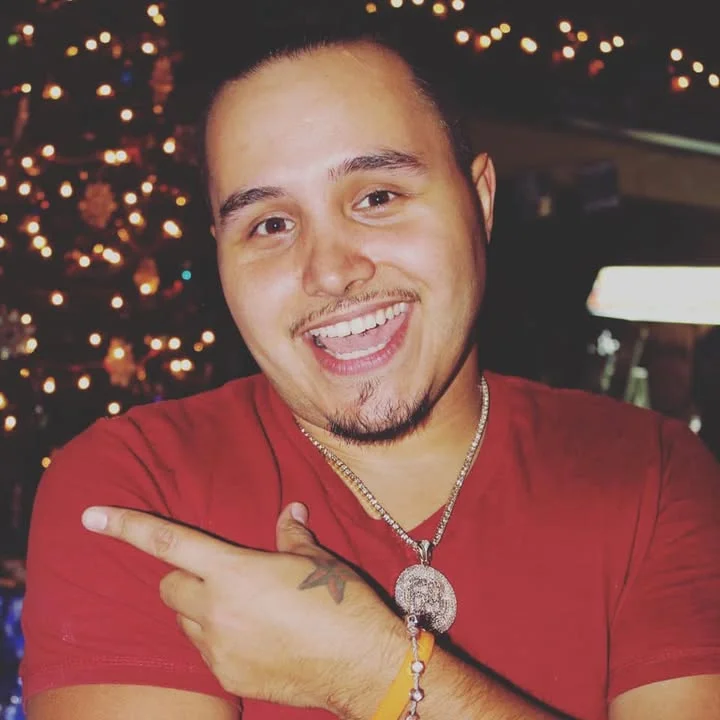 Smiling person pointing at the camera in a festive setting