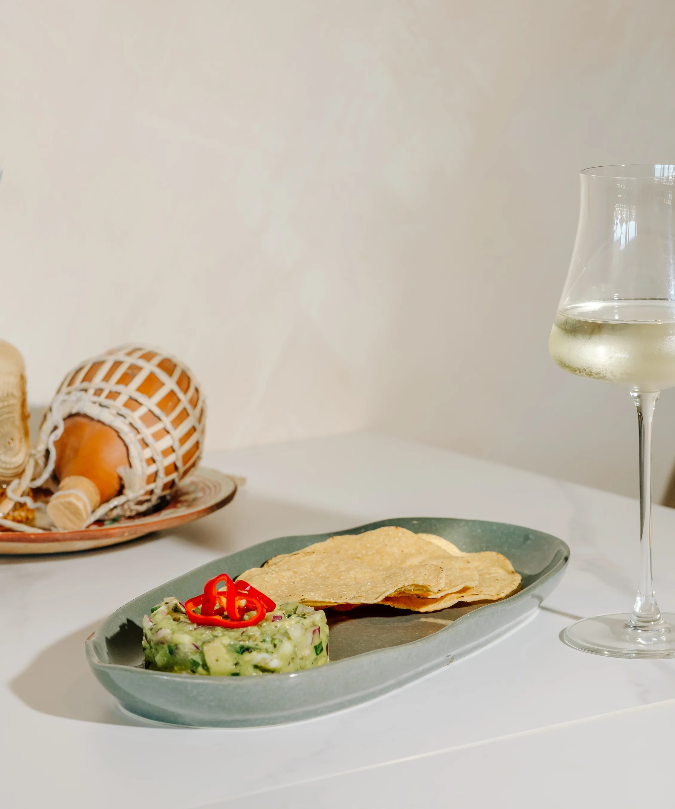Fresh guacamole with tortilla chips and white wine