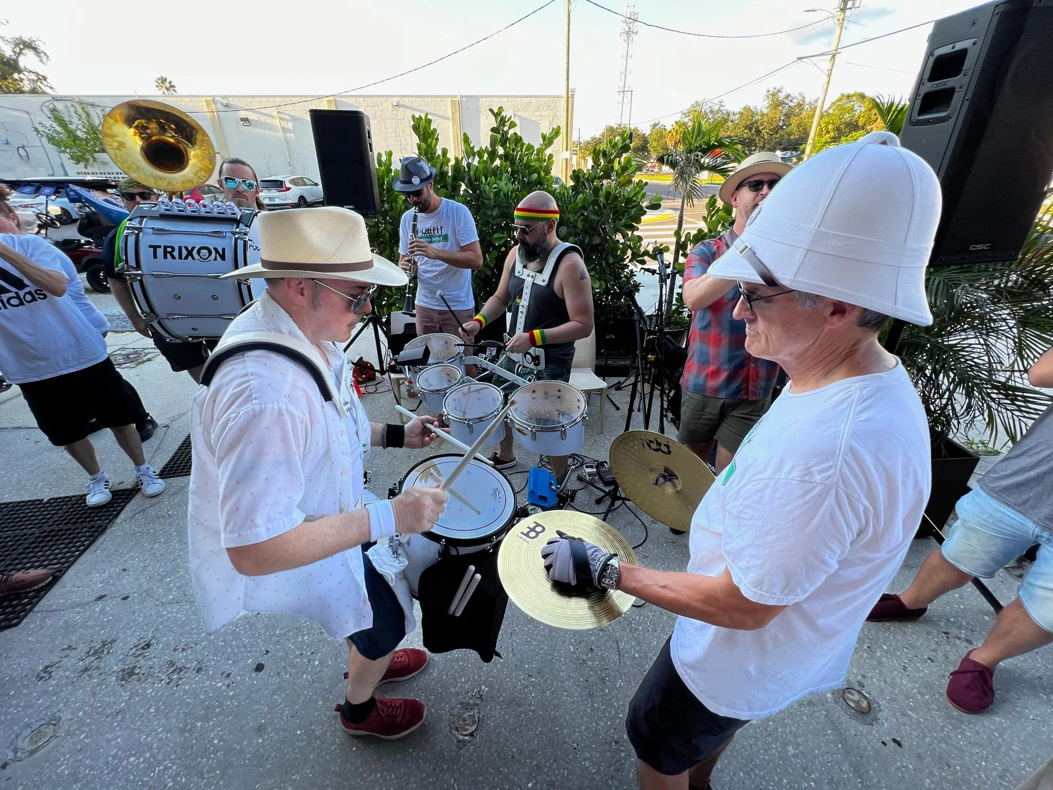 Live band performing with drums and brass instruments at an outdoor event.