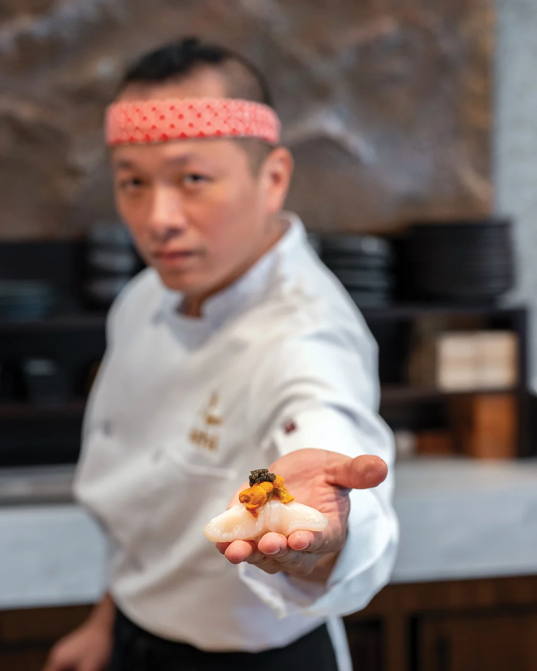 Japanese sushi with uni and caviar presented by a chef