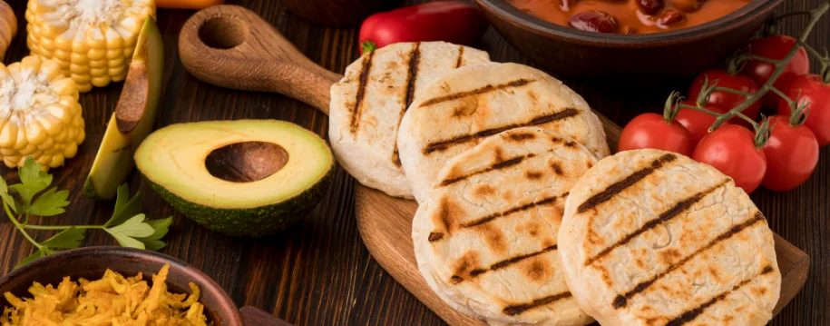 Grilled arepas served with avocado and beans