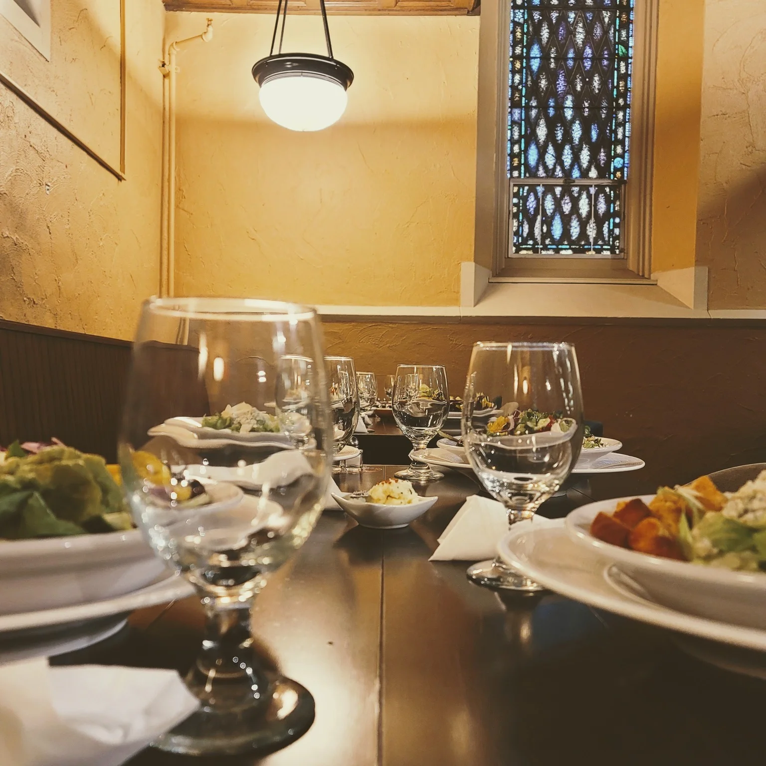 Elegant restaurant dining setup with salads and glassware