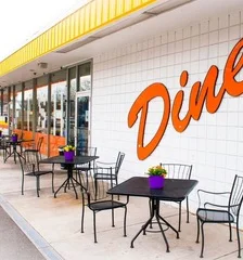 Outdoor dining area of a retro diner with tables and colorful decor
