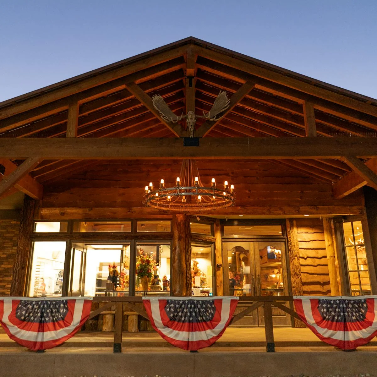 Rustic restaurant exterior with American flags and warm lighting