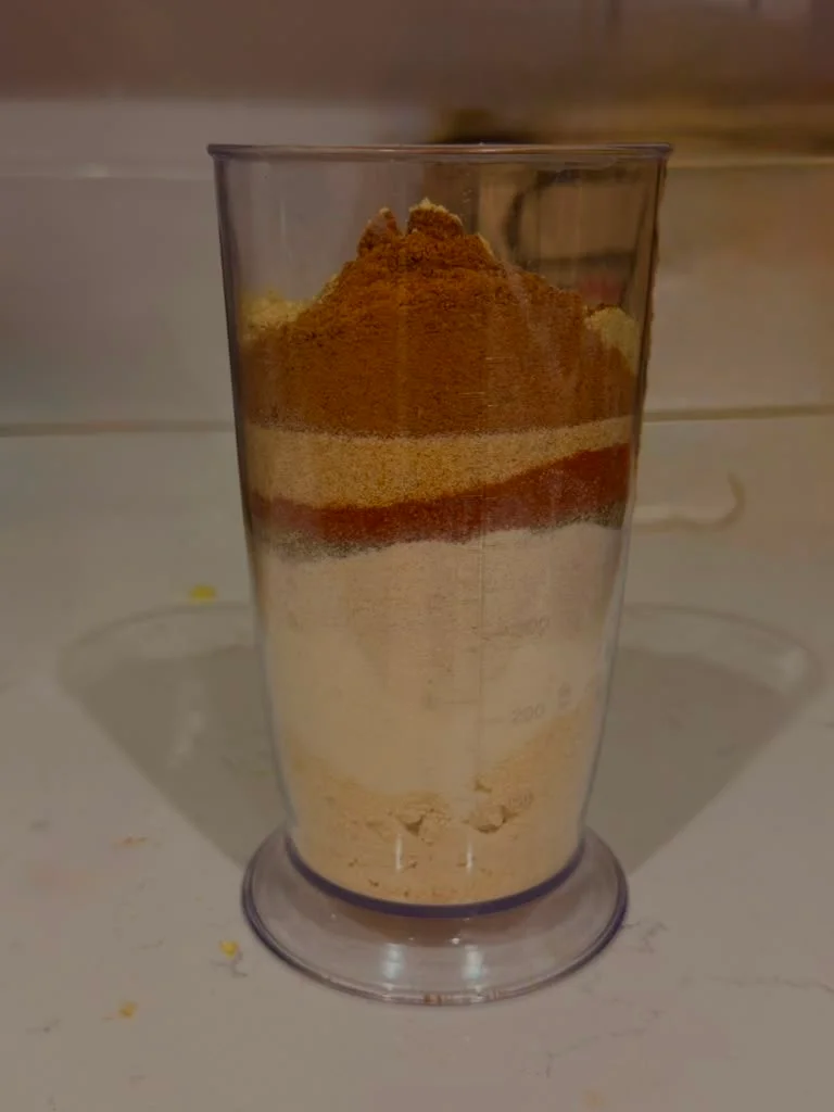 Layered spices in a clear measuring cup for culinary preparation