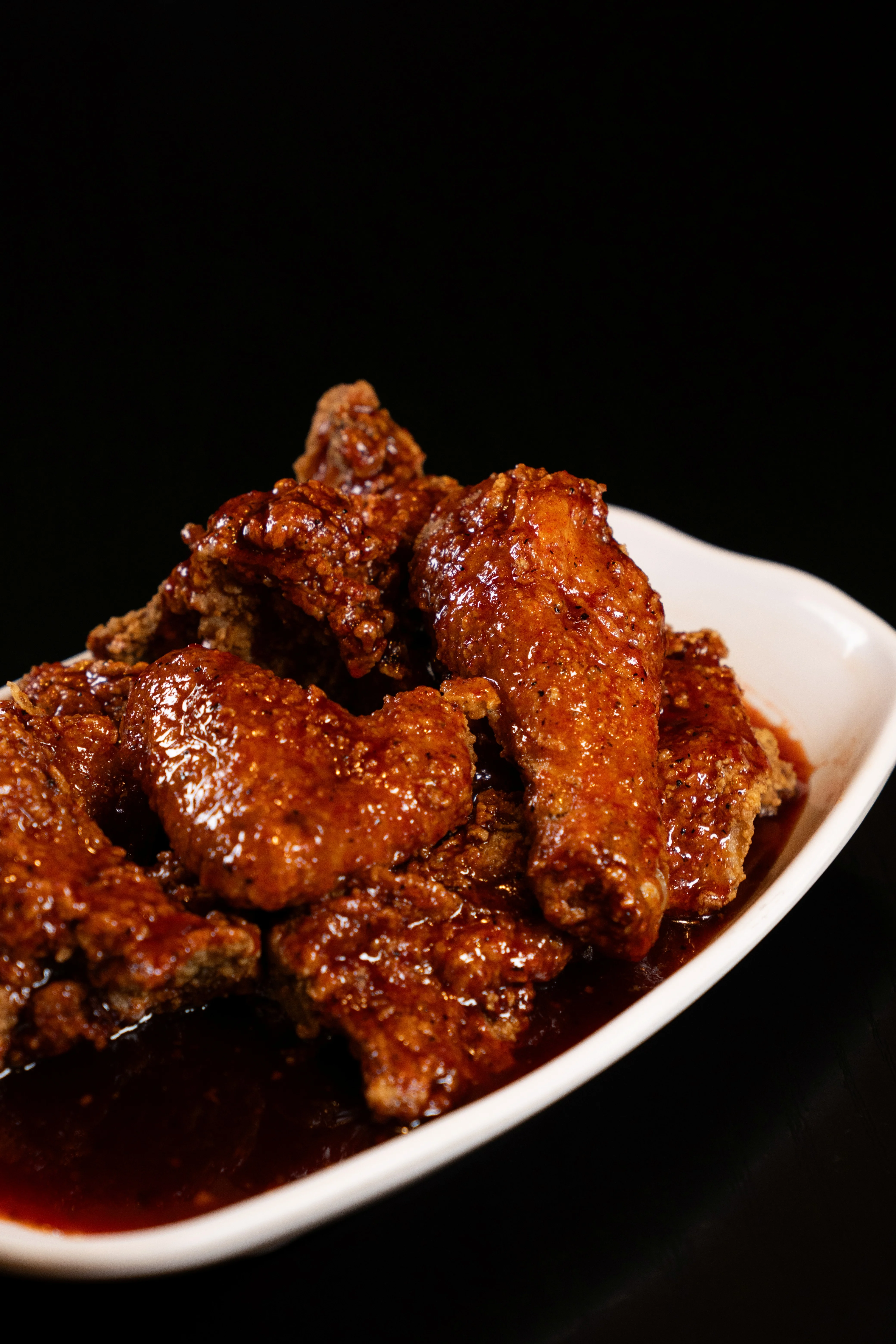 Deliciously glazed chicken wings served in a white dish.