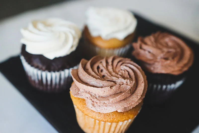 A variety of colorful cupcakes displayed on a table.
