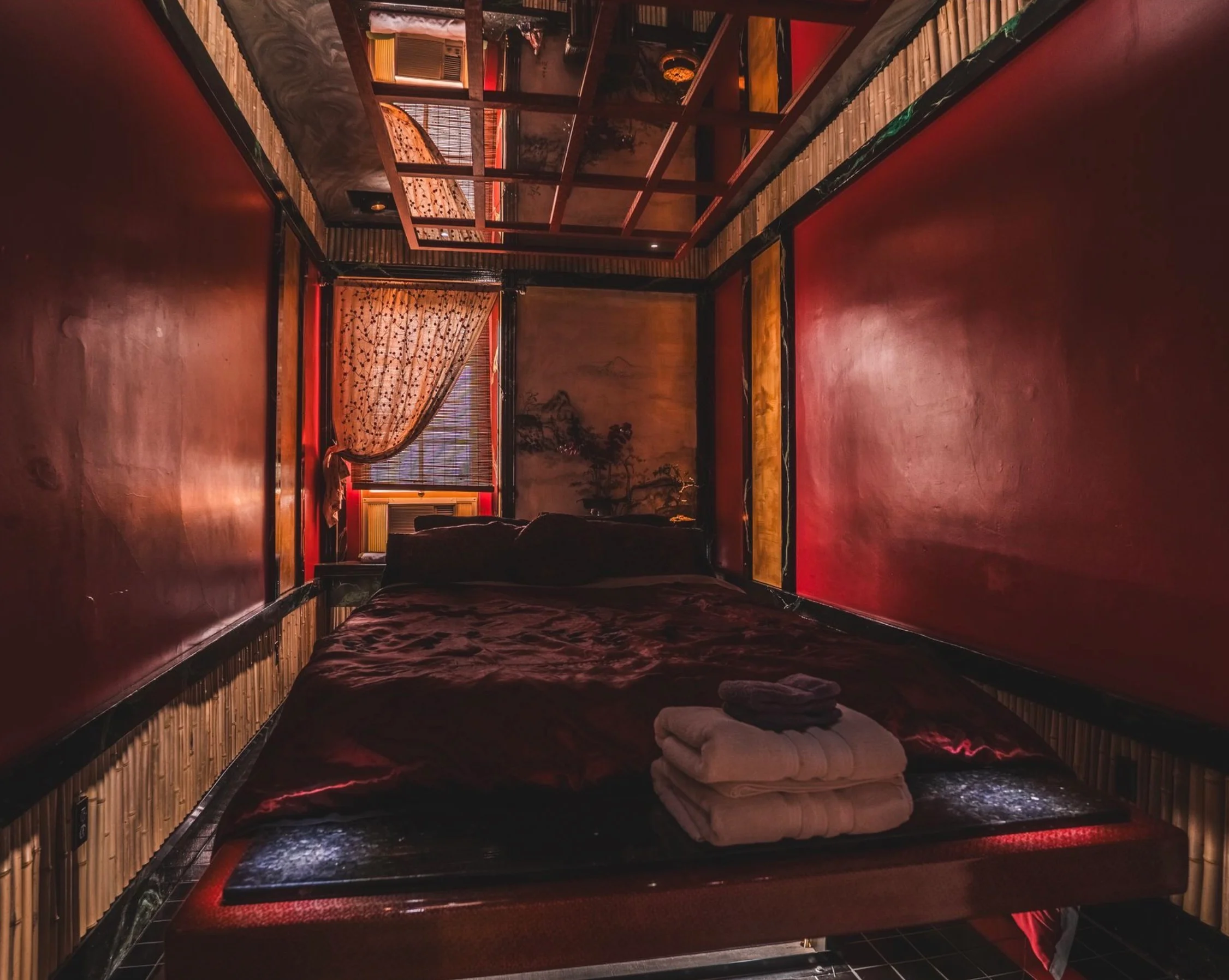 Cozy, dimly lit room with a bed and decorative curtains.