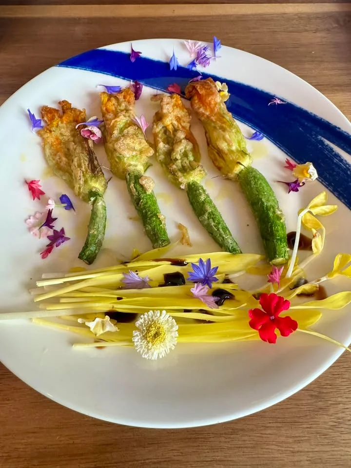 Stuffed zucchini flowers with edible flowers garnish