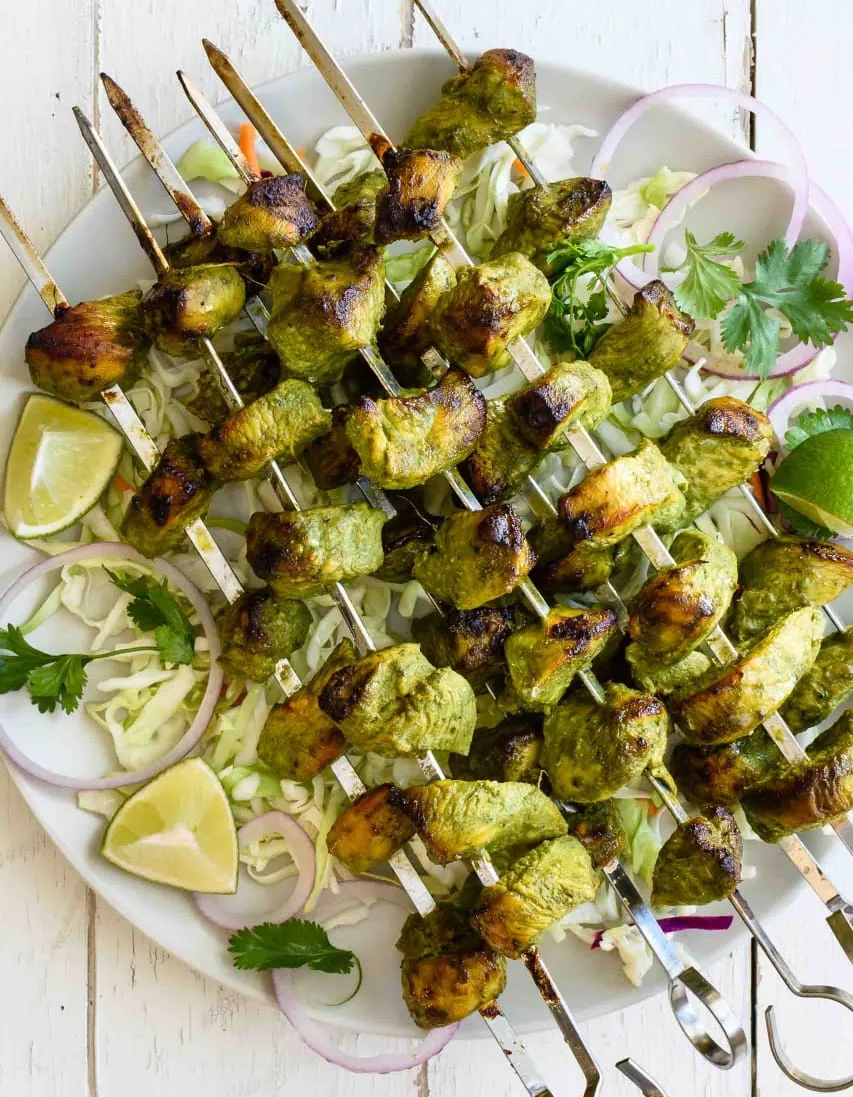 Grilled chicken kebabs on skewers with fresh herbs